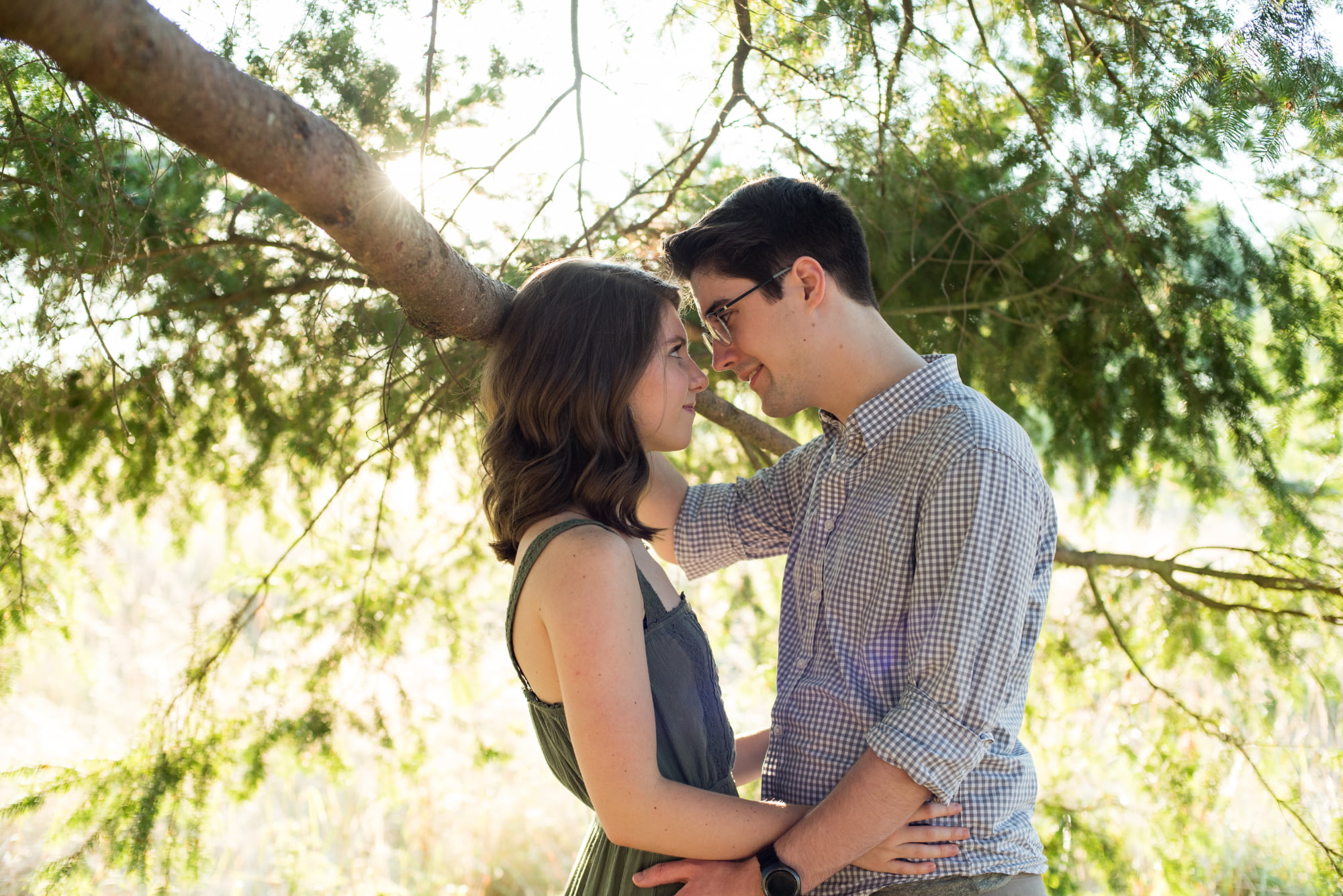 Young engaged couple underneath tree