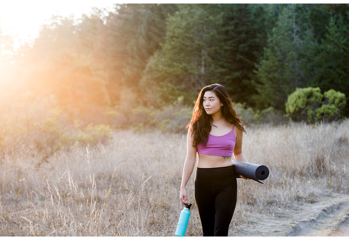 Fitness portrait of woman with yoga mat and water bottle