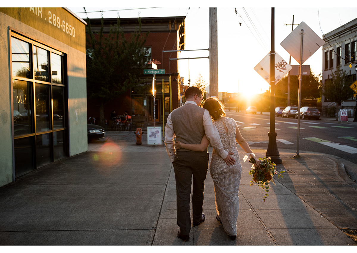 Golden hour portrait of bride and groom walking down street in North Portland