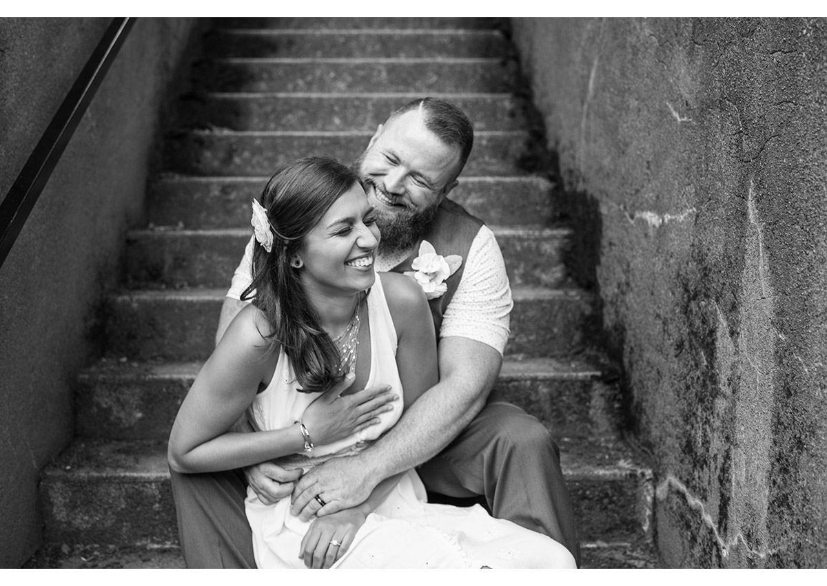 Candid of bride and groom laughing on steps near Pittock Mansion
