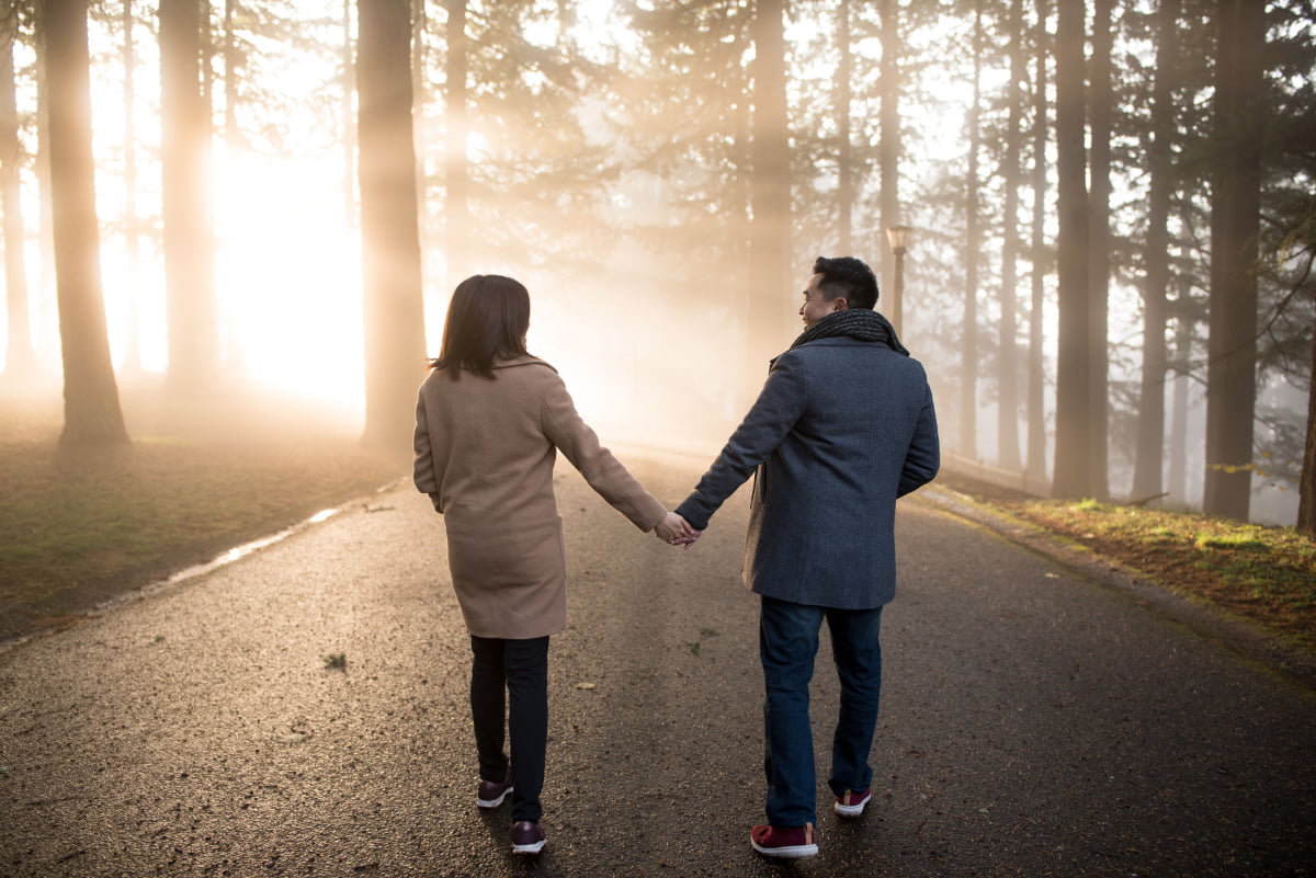 Couple holding hands and walking in the sunrays at Mt. Tabor