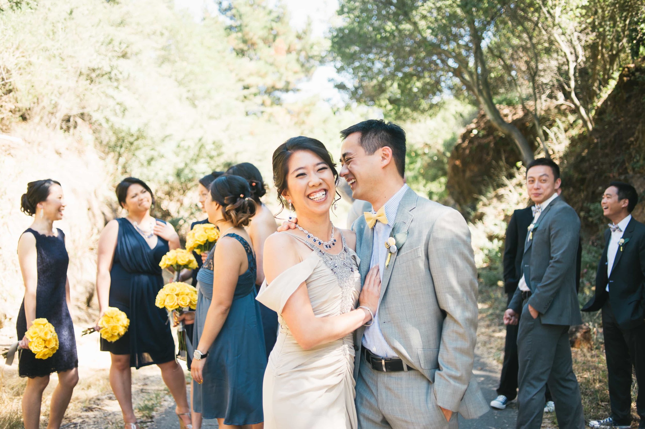 Bride and Groom laughing with wedding party behind them