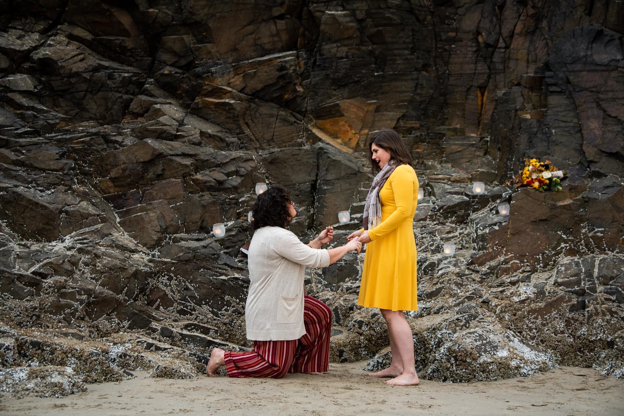 Woman on one knee proposing to girlfriend at Hug Point State Park