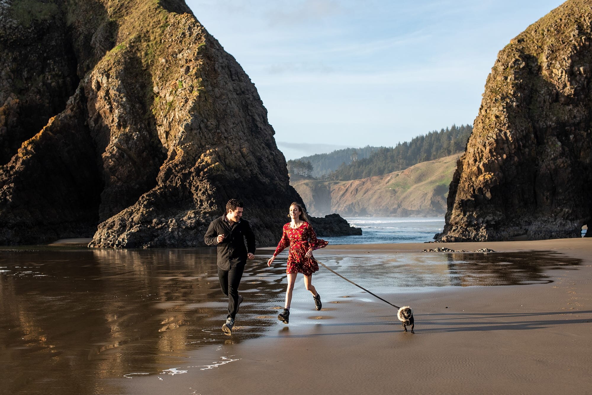 Couple running with small dog during engagement session