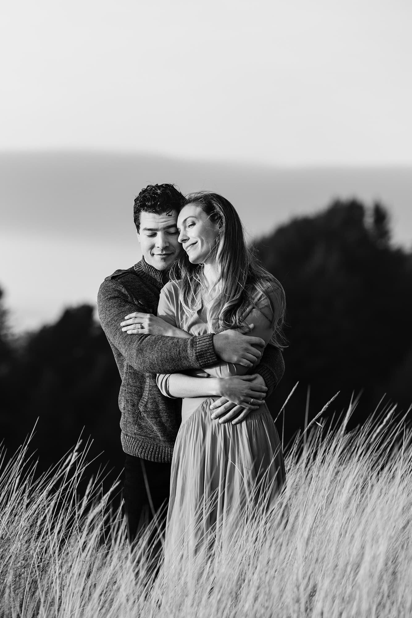 Couple embracing in beachgrass at Cannon Beach