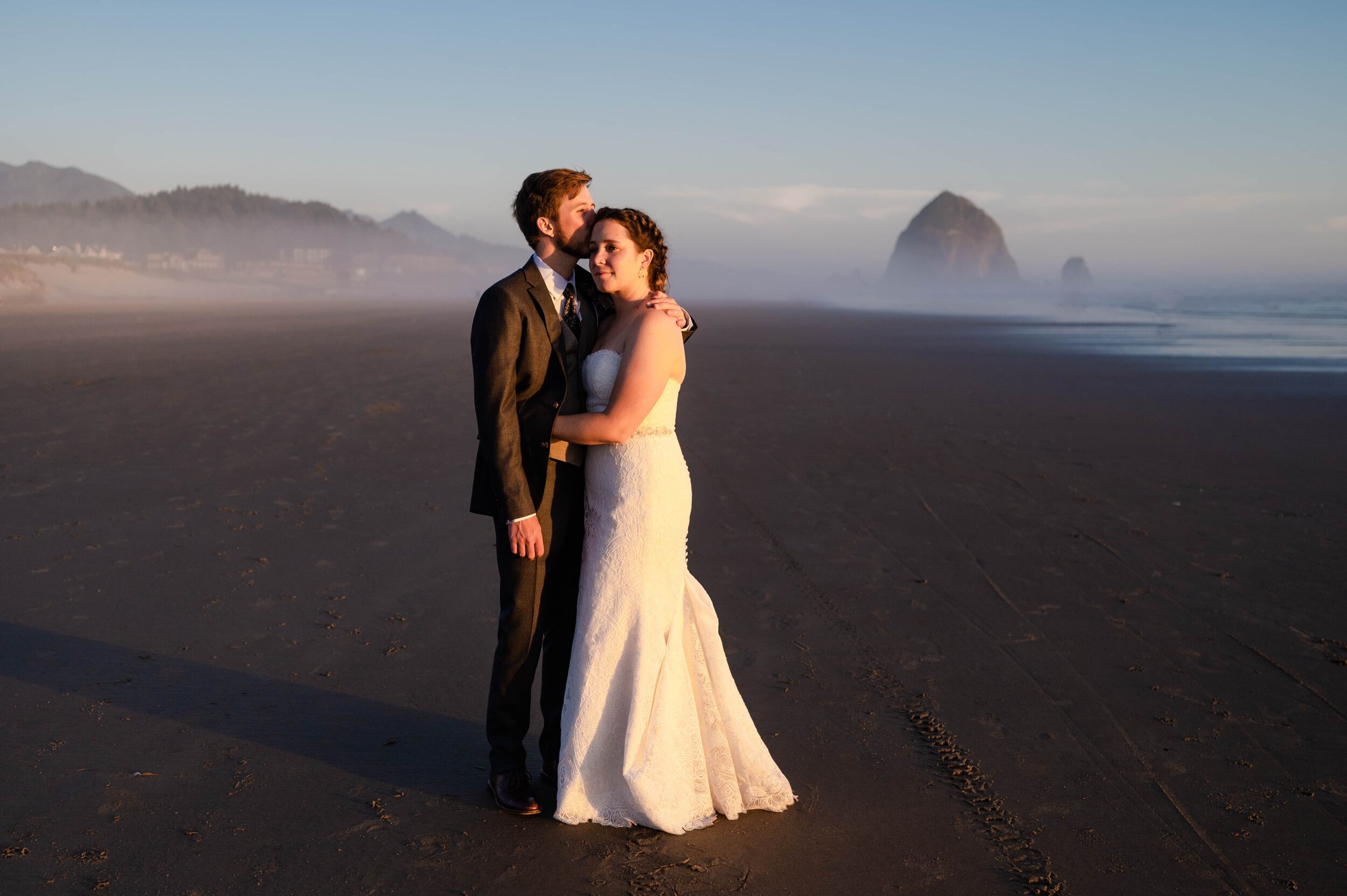 Couple on Cannon Beach after wedding with Haystack Rock in background