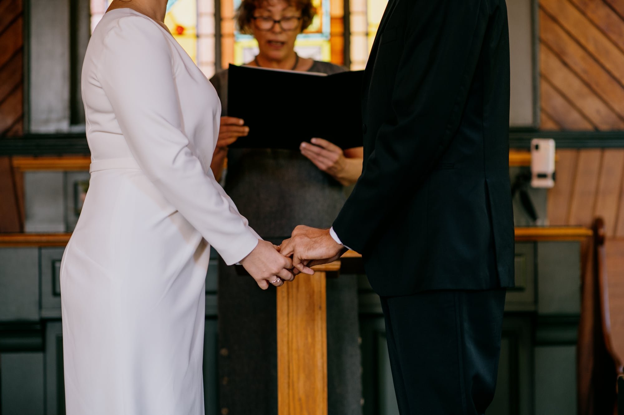 Detail of couple holding hands during ceremony