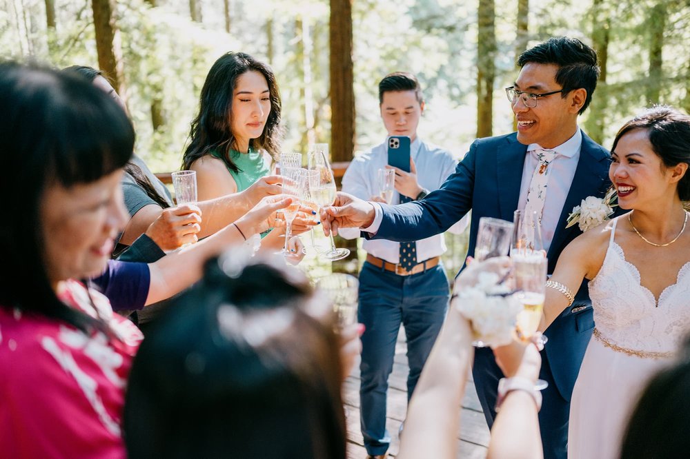 Wedding guests cheers with bride and groom on Redwood Deck