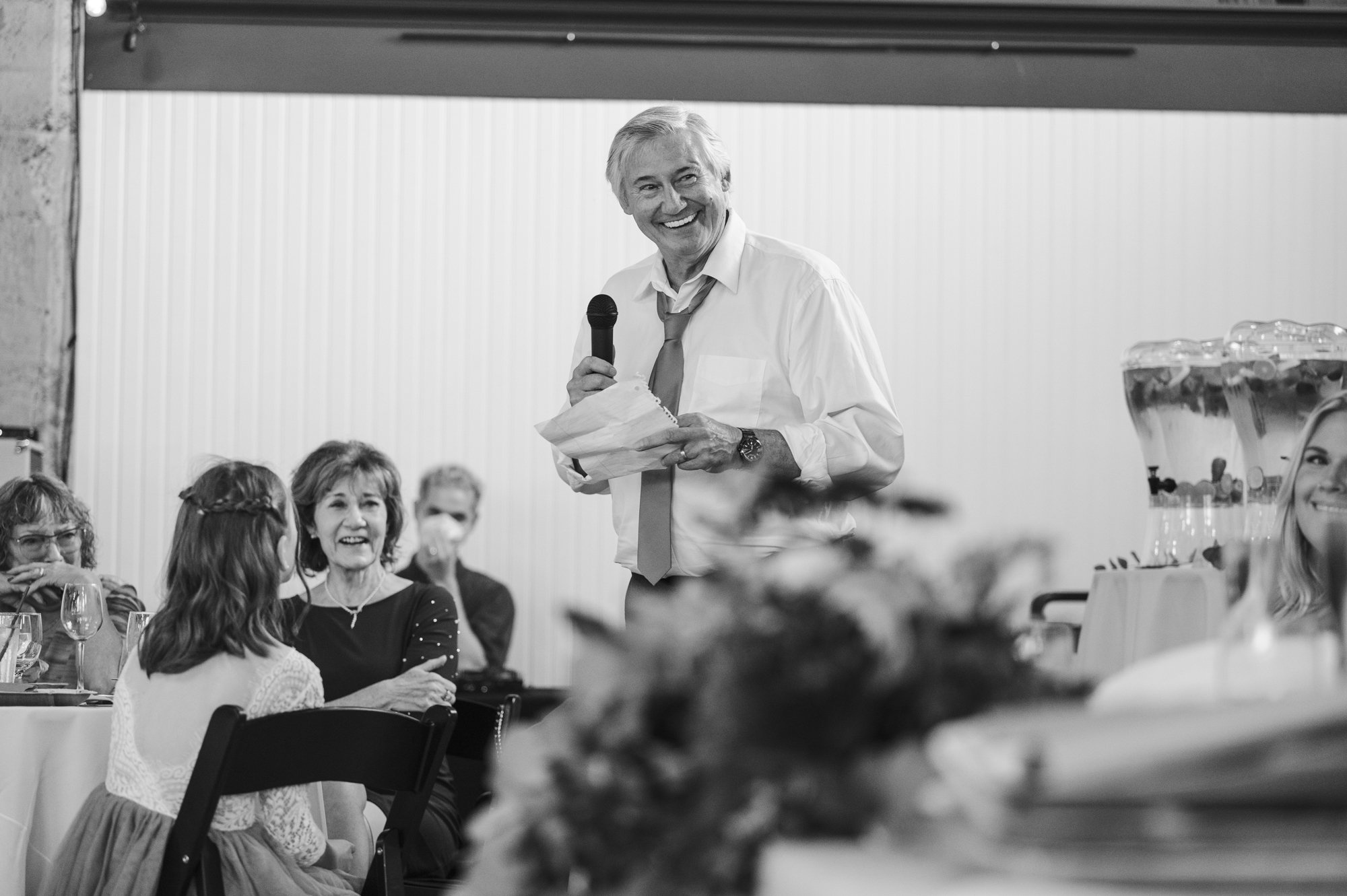 Candid photo of father of the groom giving toast