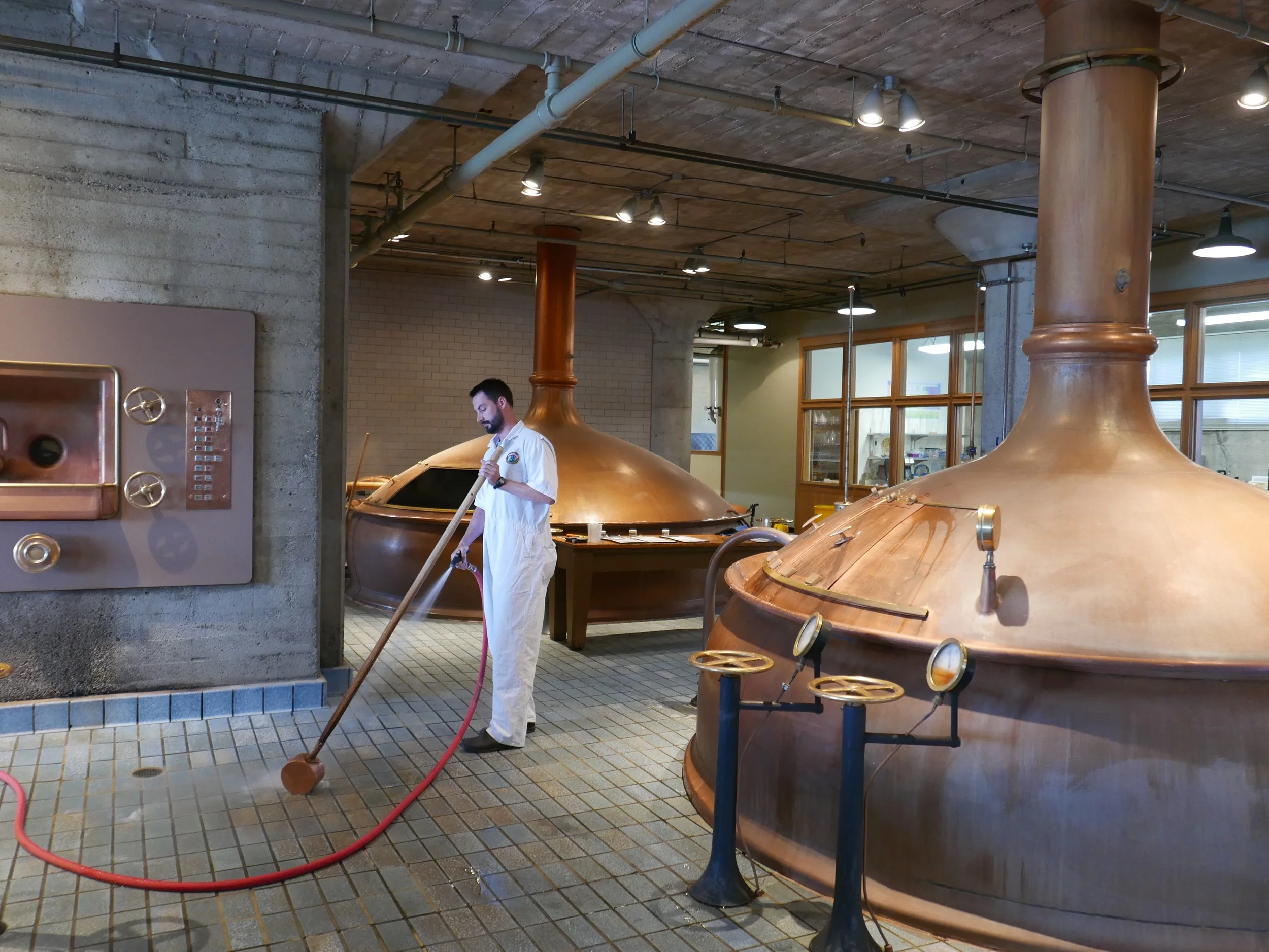 A brewer at Anchor rinsing his sample stick after testing the boiling wort in the kettle.