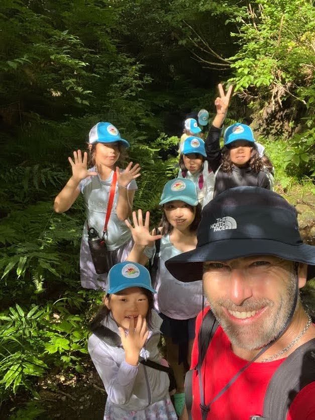  インストラクターと一緒に自然のトレイルを進むキャンパー 