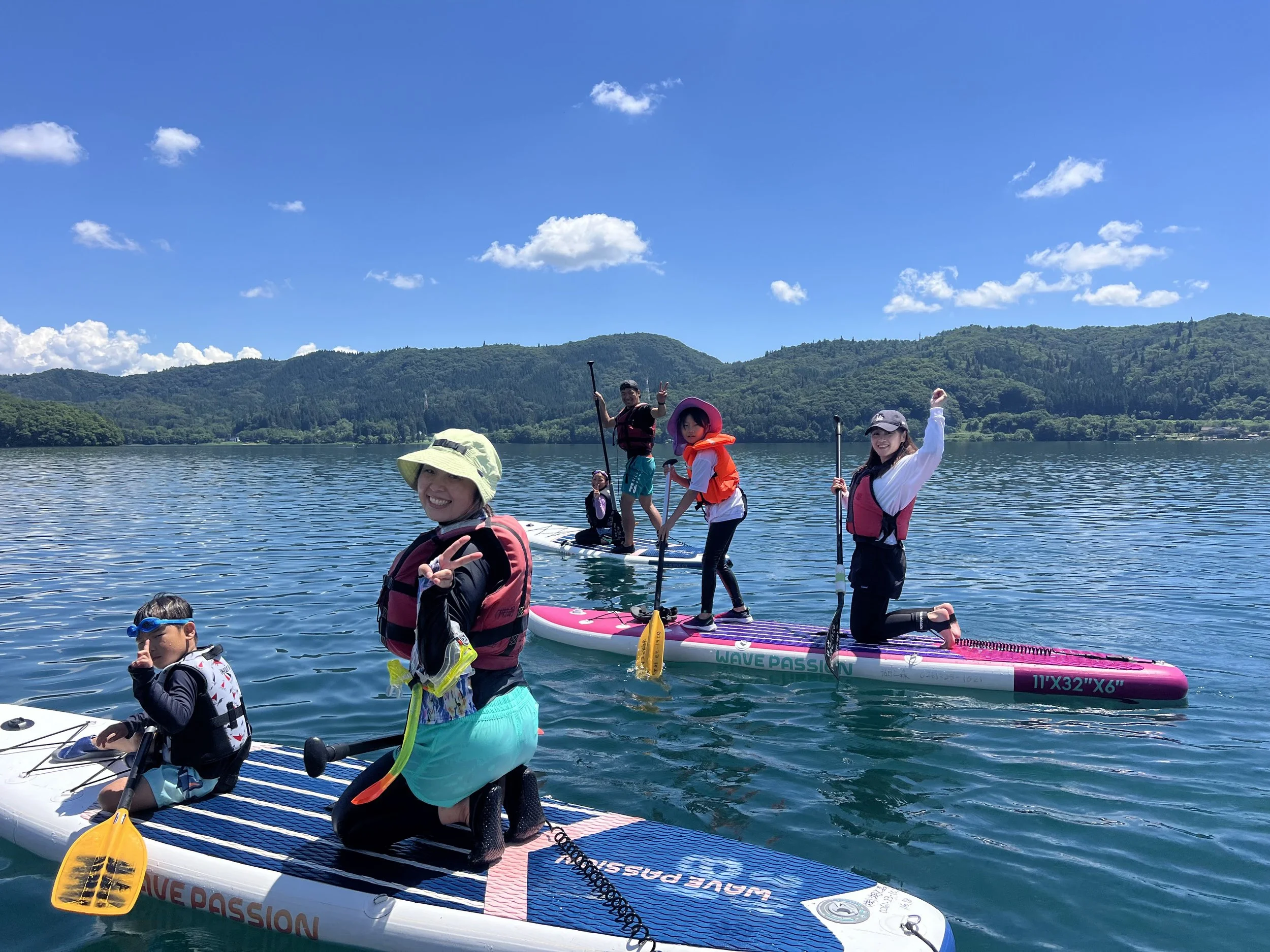 湖の上でSUPに挑戦する子どもたちの笑顔