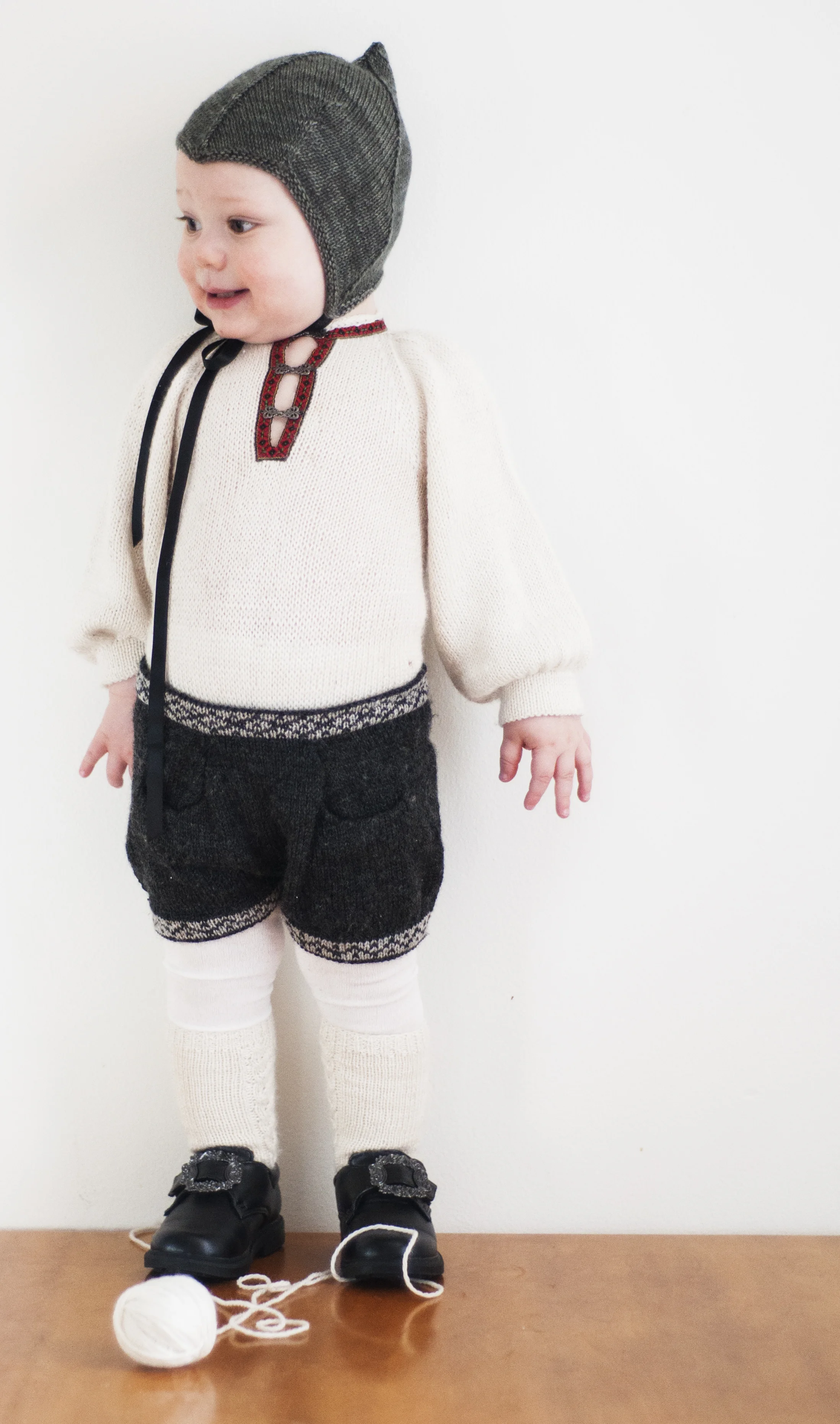 Klassisk bunadslook - med babytilpasning. Bomullsskjorter til småbarn krøller seg oppunder haka før du rekker å snu deg - temperert og myk bunadsbody sammen med en tøff bunadsshorts med lommer holder antrekket på plass