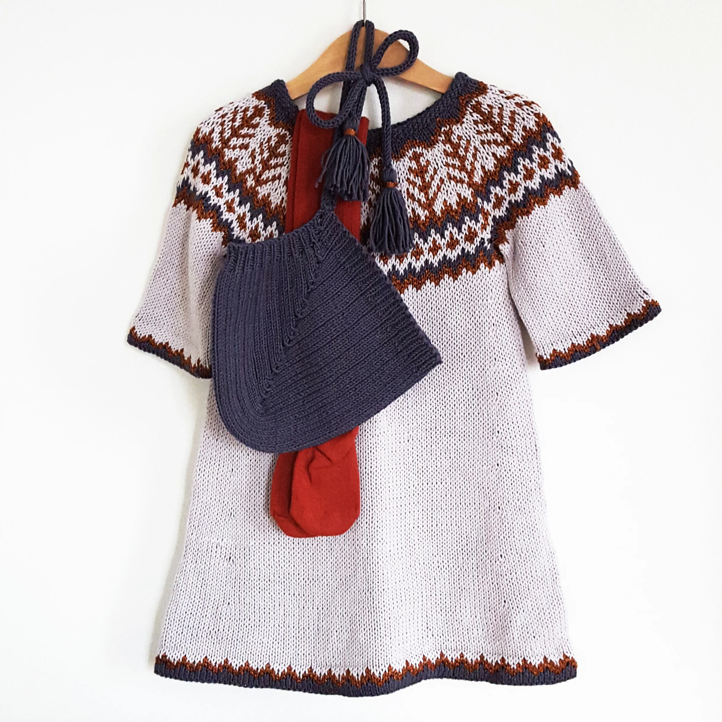 Nye emblatunika kan strikkes i bomullsgarn og lette farger, vide halvermer gir en fantastisk sommerkjole de første årene og tunika de neste. Emblamønsteret er skrevet i Islandsk stil som er utrolig enkelt å følge, og strikkes ovenfra og ned for supe…