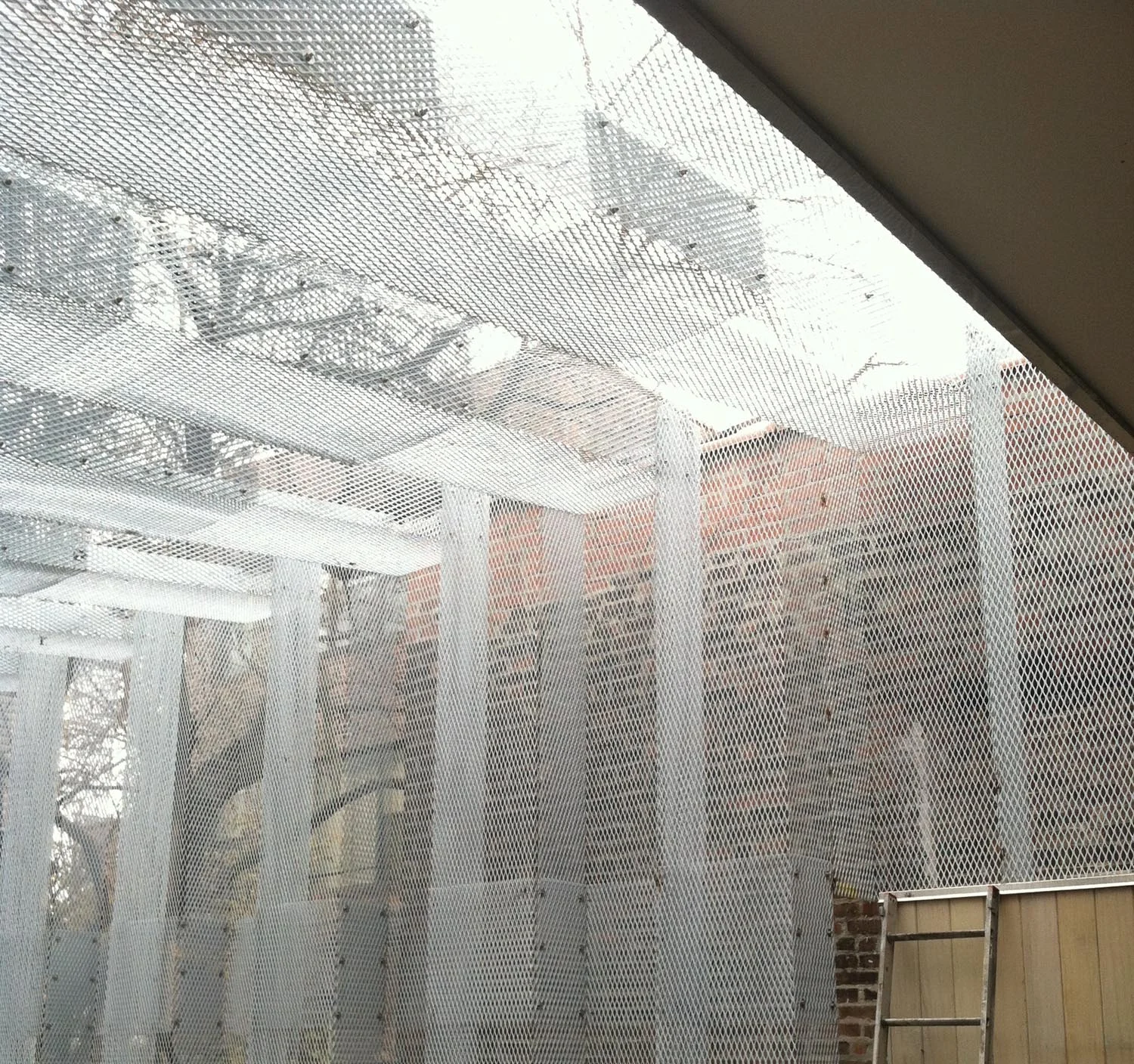   View  &nbsp; scouting shot of the construction process, the mesh panels have a weightless quality as they filter the views beyond 