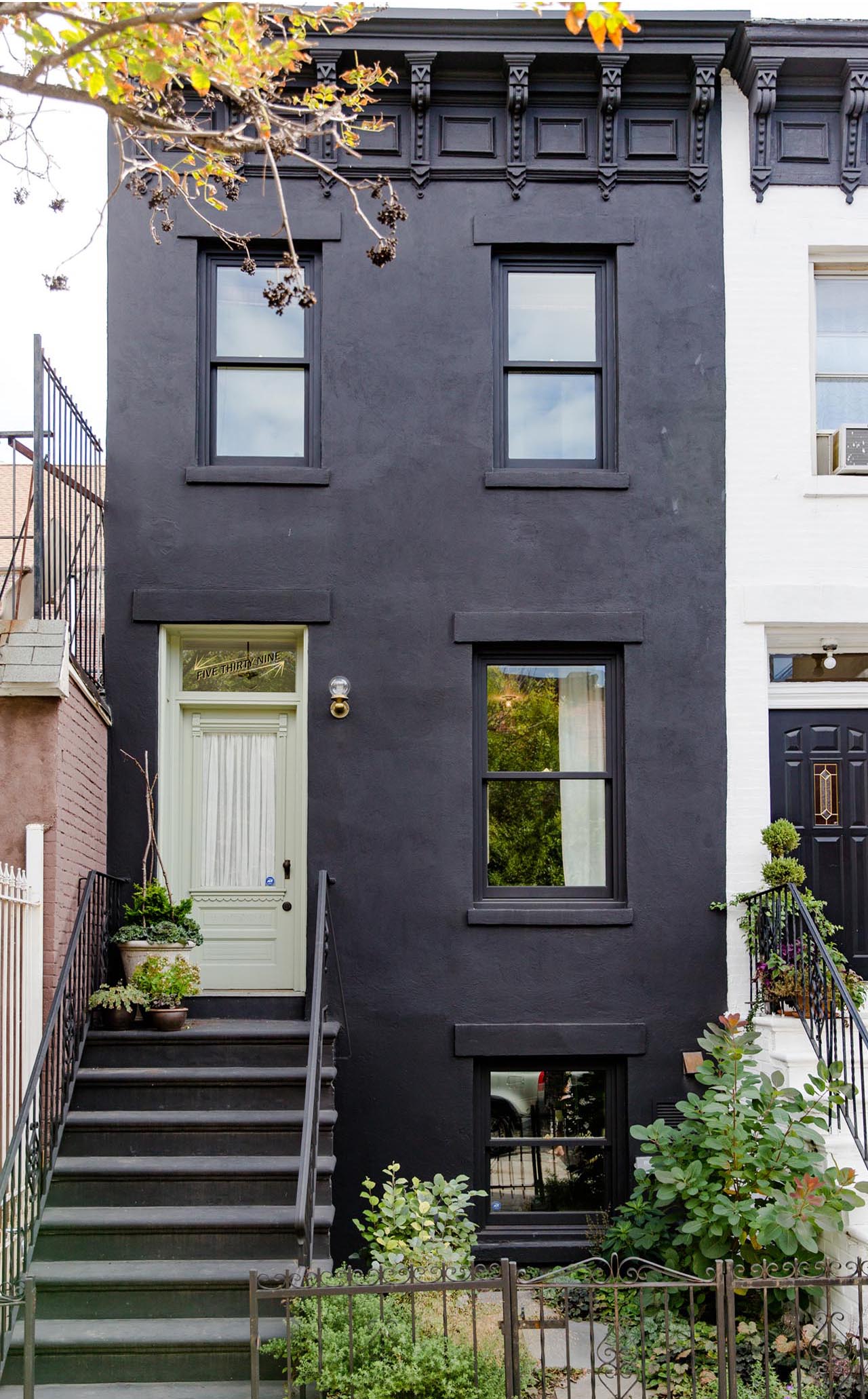   Facade &nbsp; &nbsp;the cement stucco and dark paint hint at a new life contained within 