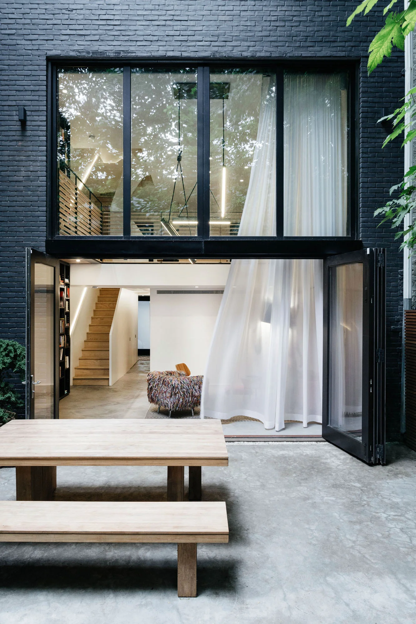   Connection   The double height glass wall fully opens at the lower level extending the interior space into the garden 