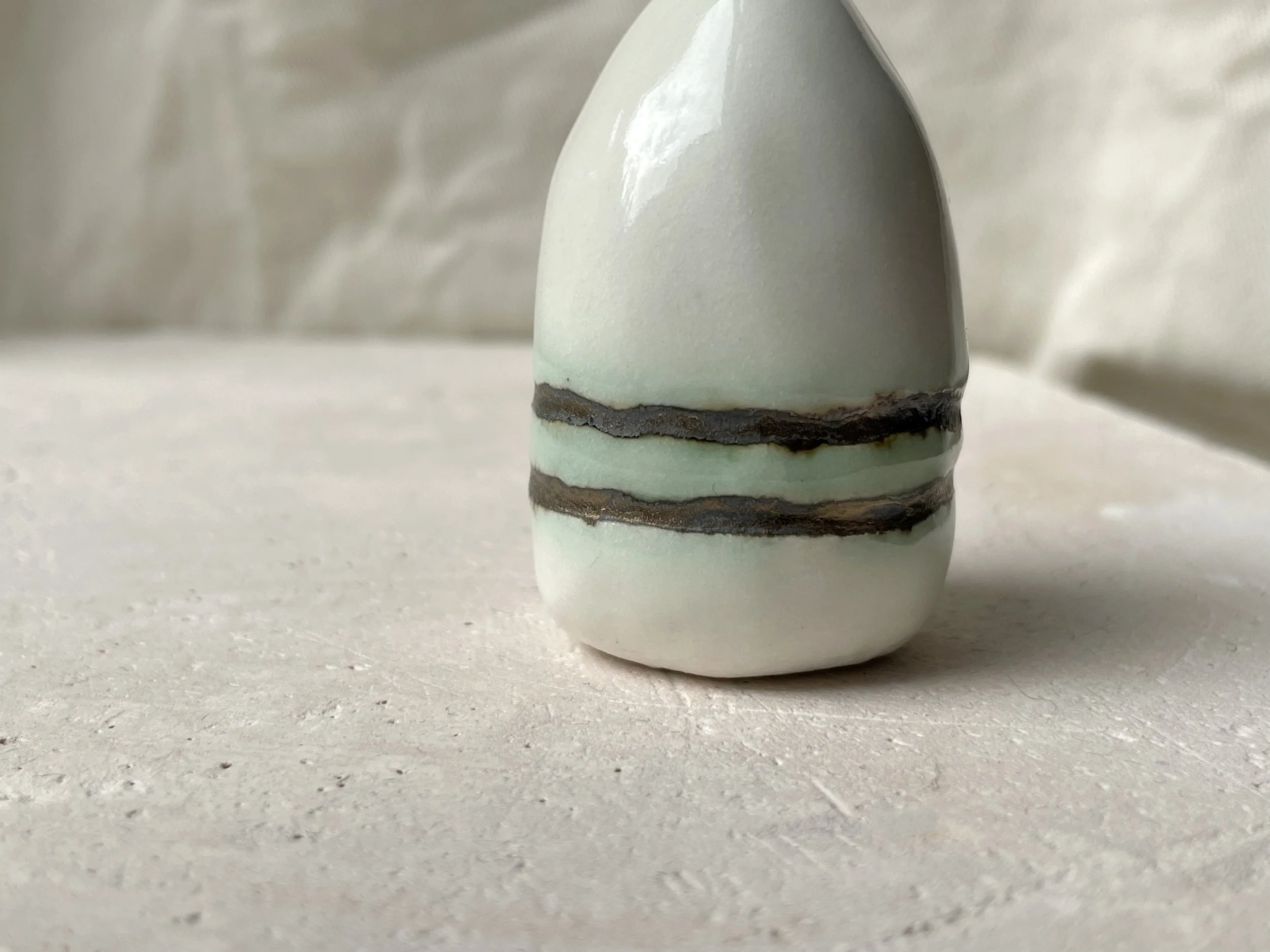 gold and white with hints of green handmade figurative ceramic sculpture with underglaze and glaze