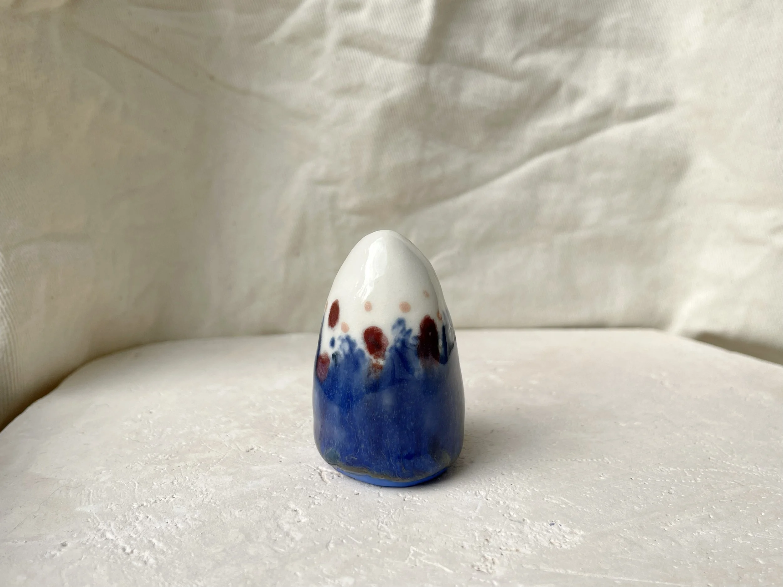 blue, white, red and pink handmade figurative ceramic sculpture with underglaze and glaze