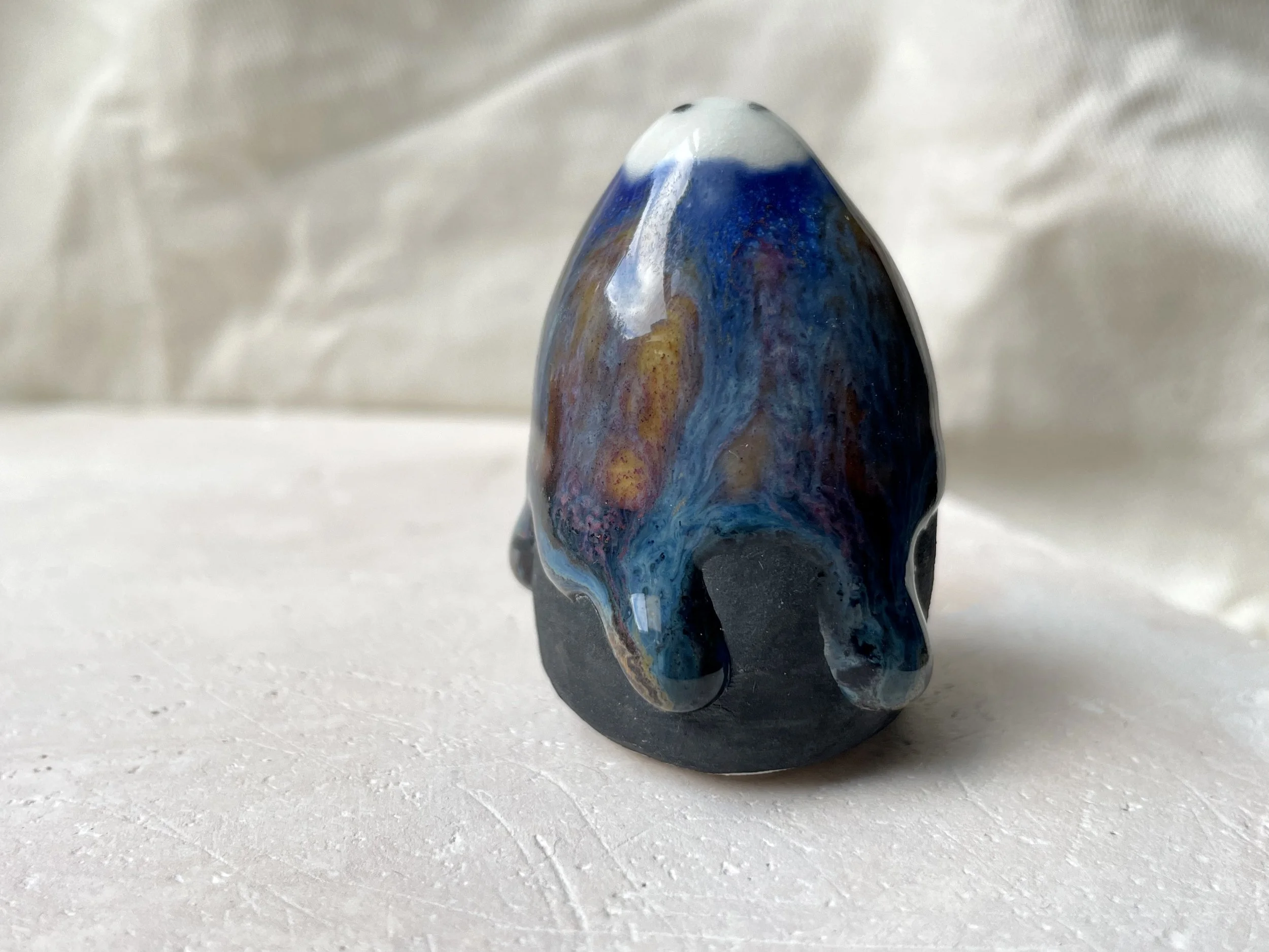 Blue, orange, purple and black handmade figurative ceramic sculpture with underglaze and drippy float glaze