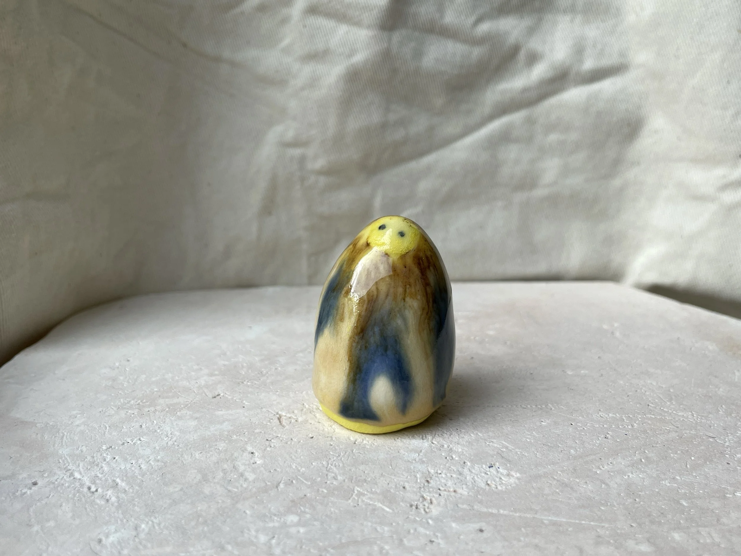 Yellow, brown, blue and cream handmade figurative ceramic sculpture with glossy drippy glaze