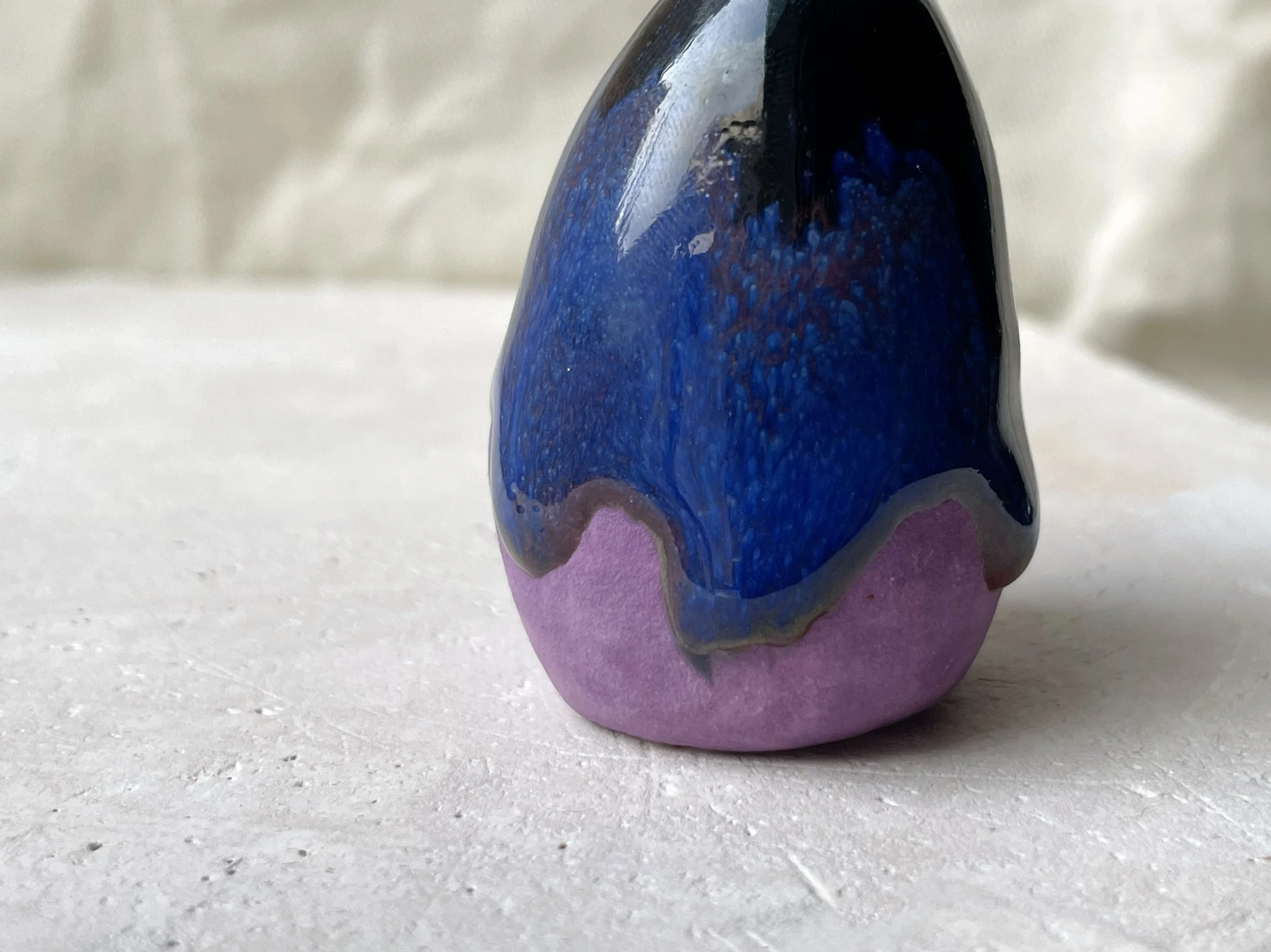 Purple, blue and black handmade figurative ceramic sculpture with glossy drippy glaze