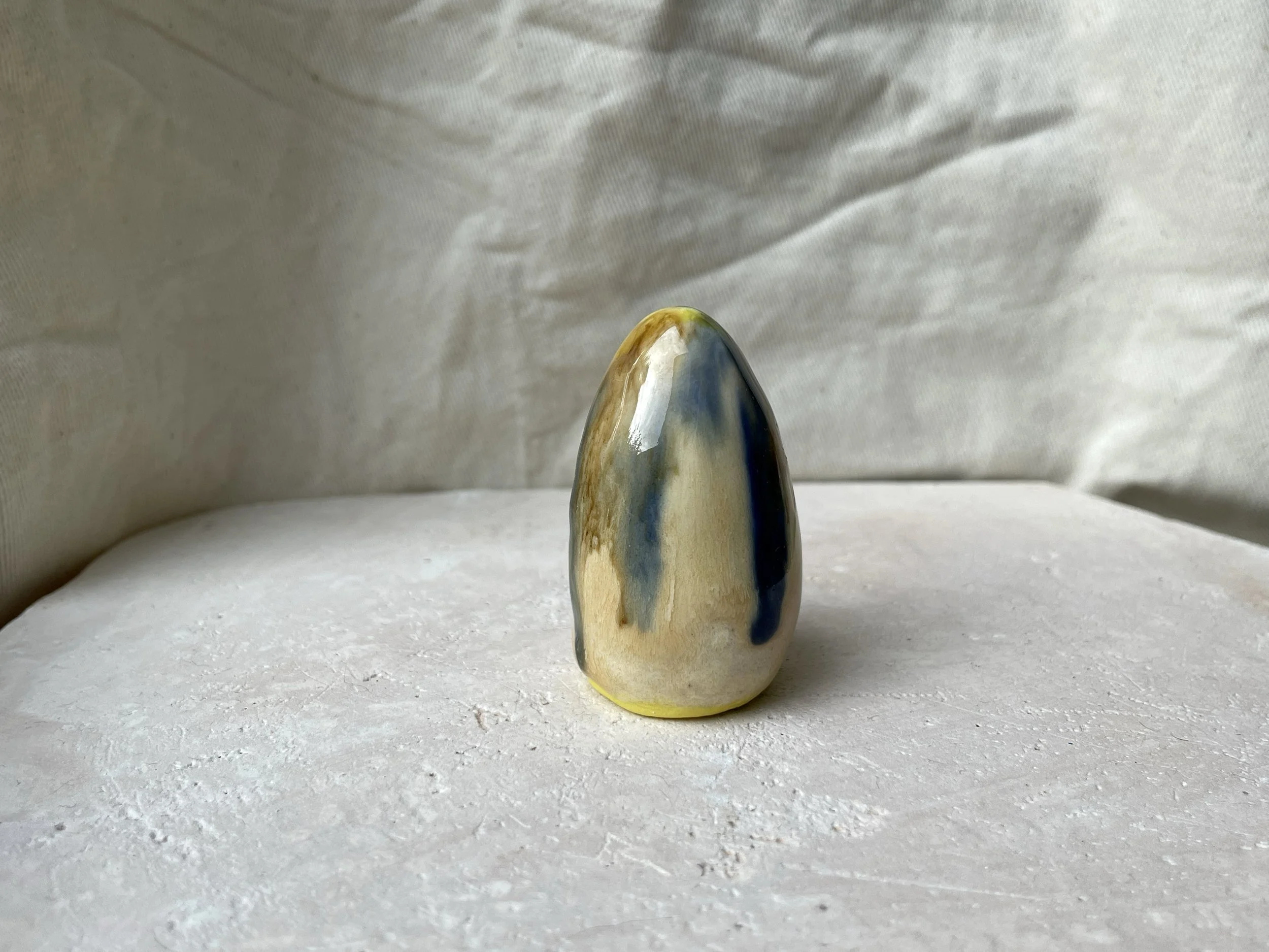 Yellow, brown, blue and cream handmade figurative ceramic sculpture with glossy drippy glaze
