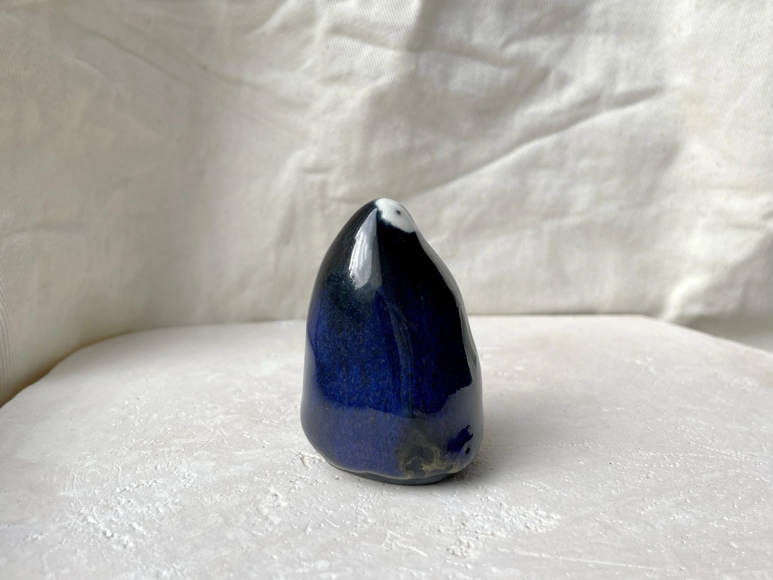 black and blue and gold handmade figurative ceramic sculpture with glossy floating glaze