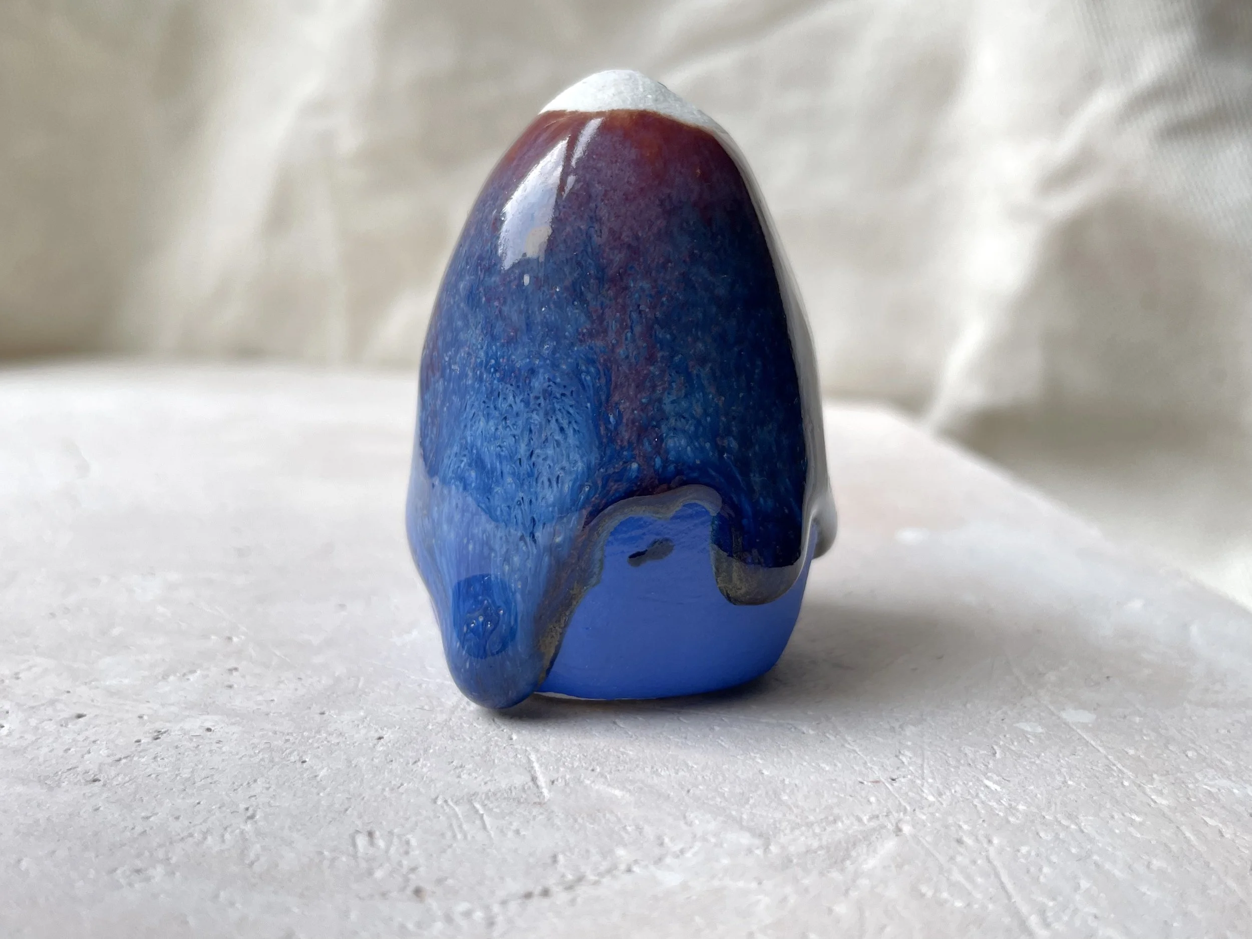 Red, blue and gold handmade figurative ceramic sculpture with underglaze and drippy runny glaze