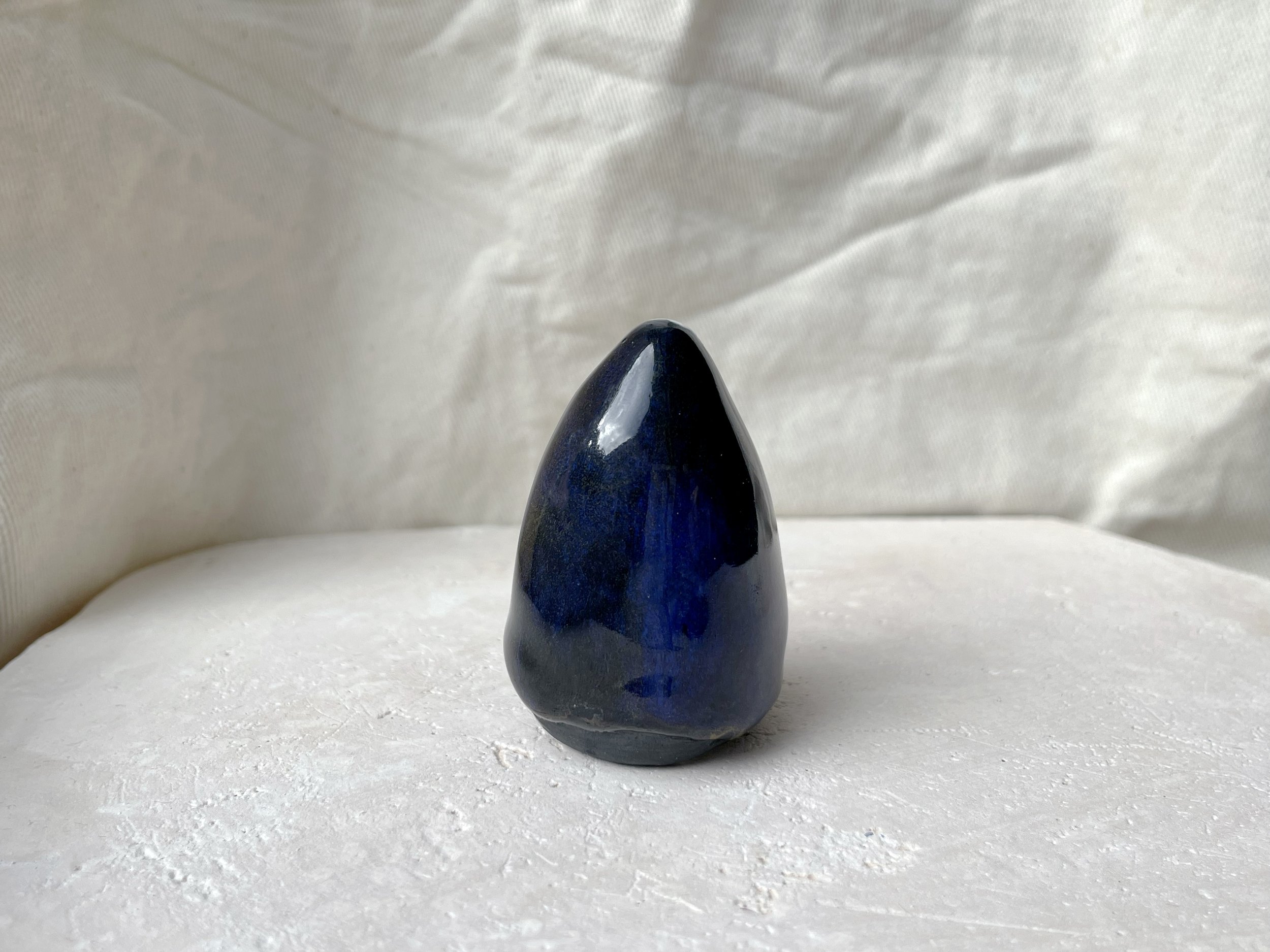 black and blue and gold handmade figurative ceramic sculpture with glossy floating glaze