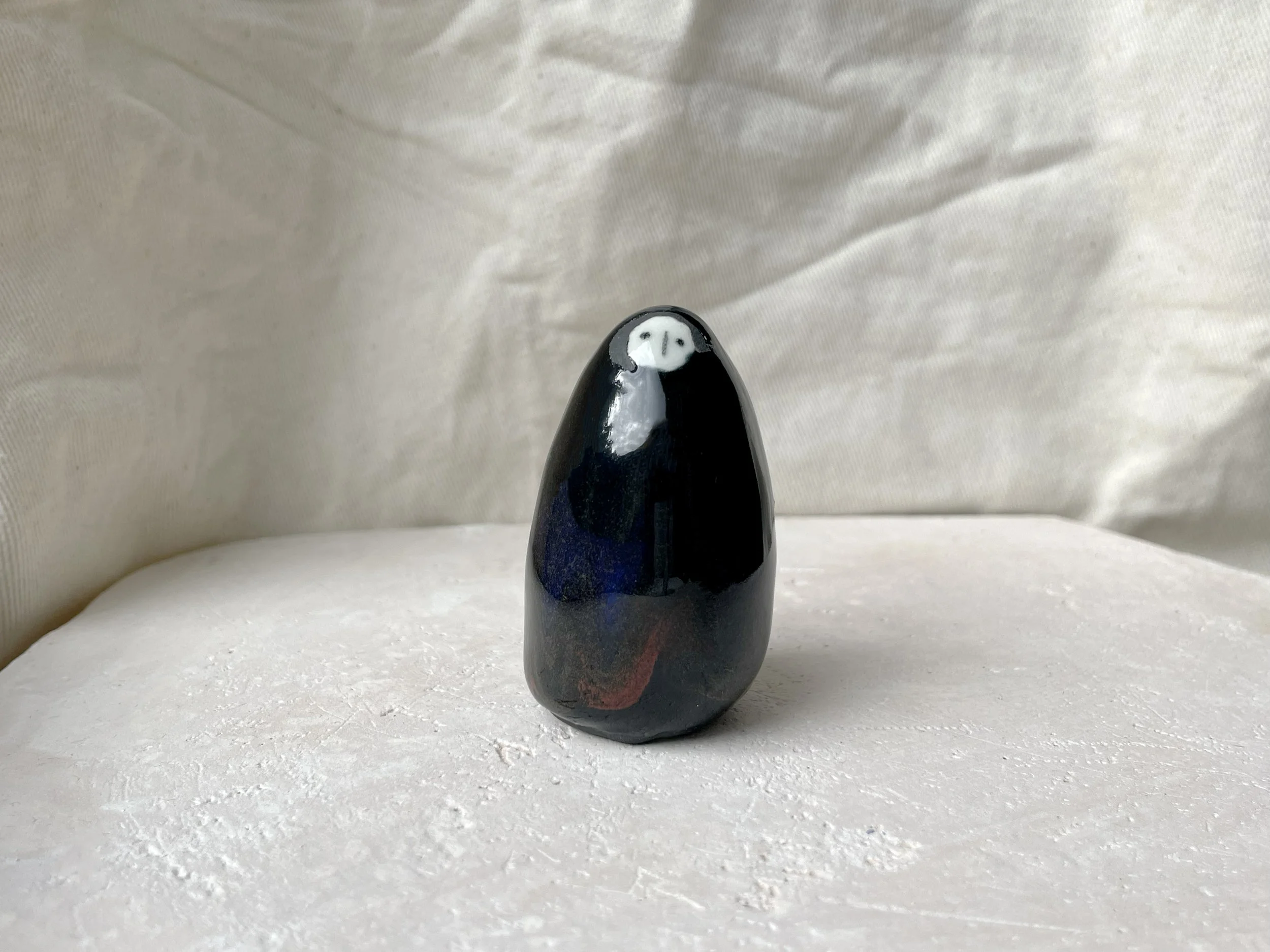 black blue and red handmade figurative ceramic sculpture with glossy floating glaze