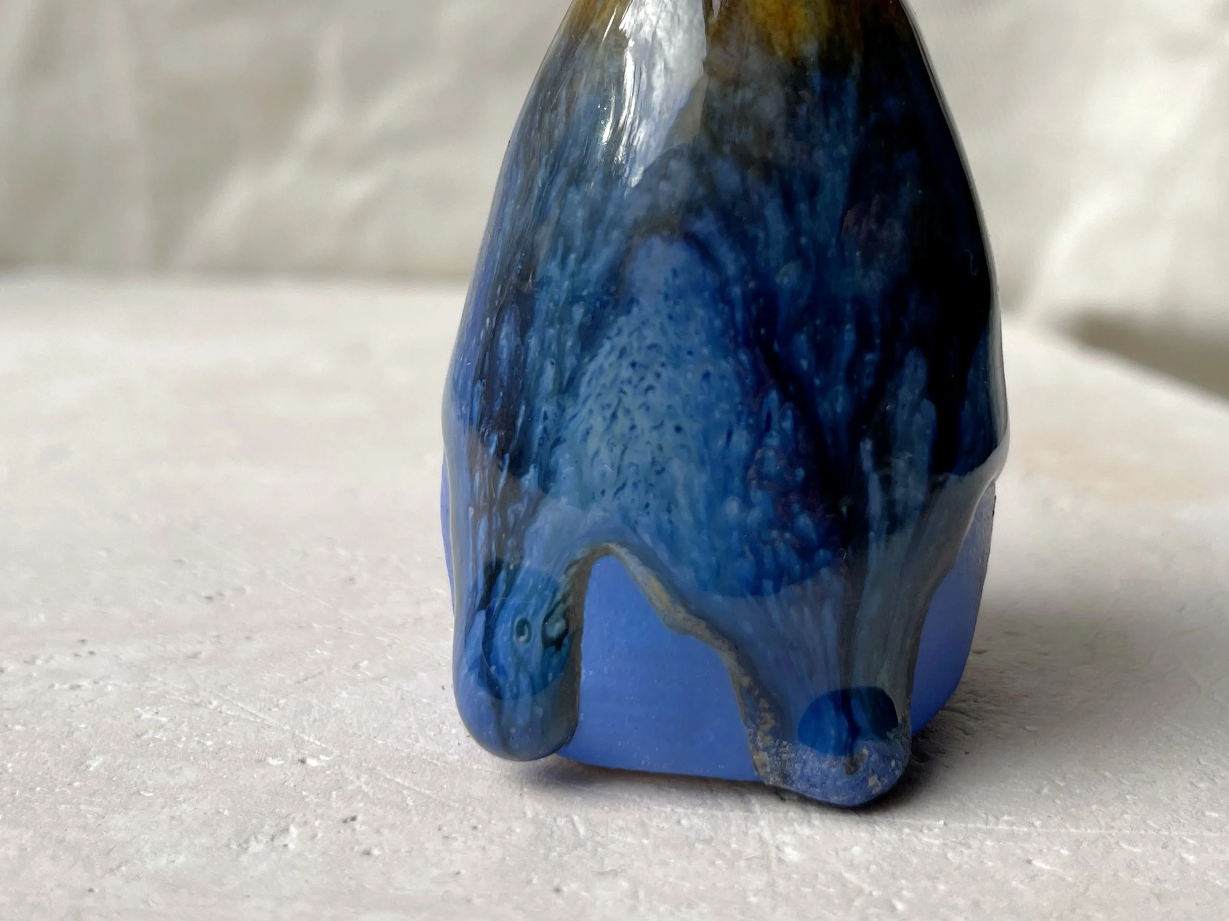 Blue, yellow, black handmade figurative ceramic sculpture with glossy runny floating glaze