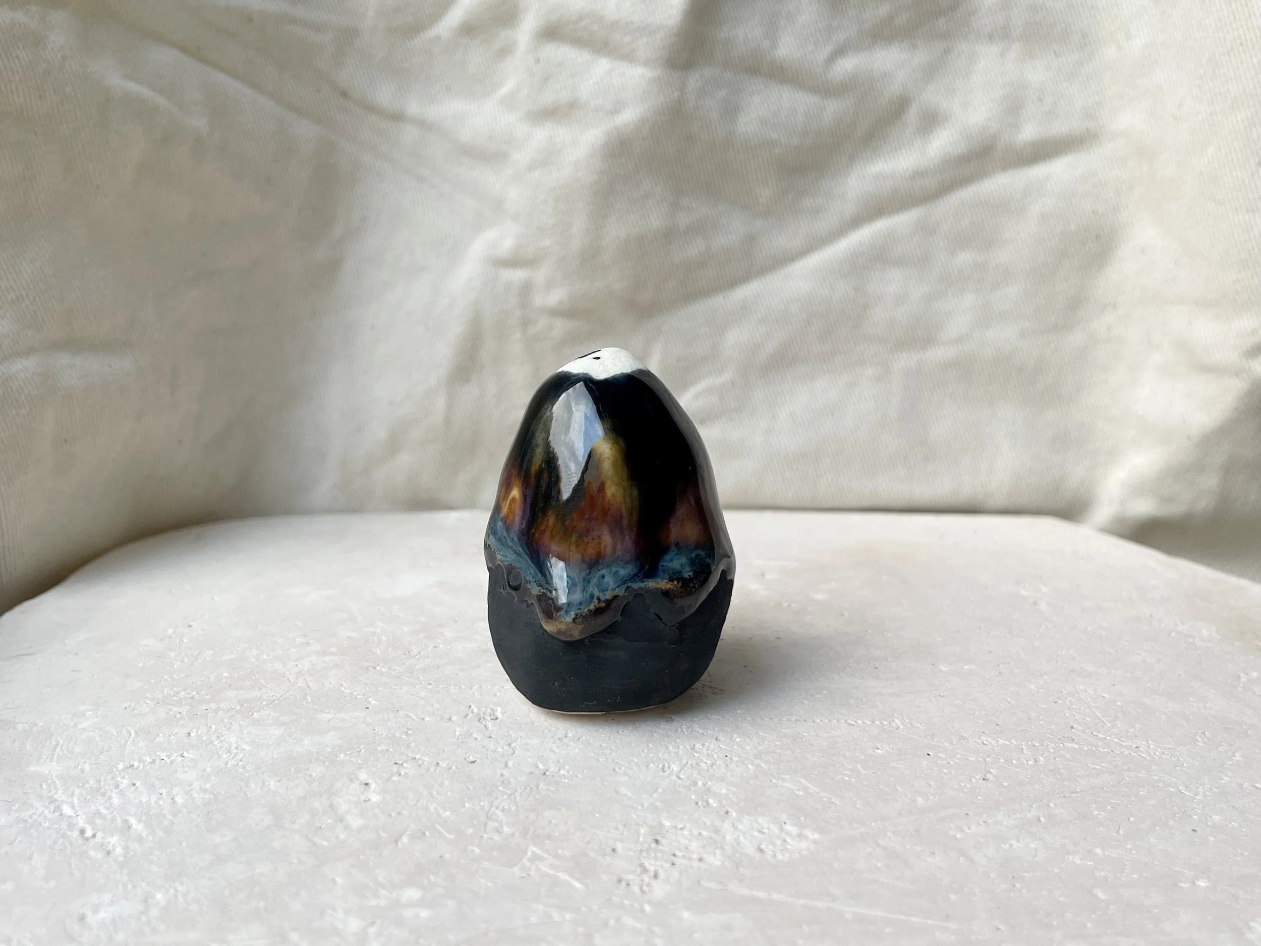 Black, orange and blue handmade figurative ceramic sculpture with underglaze and drippy float glaze
