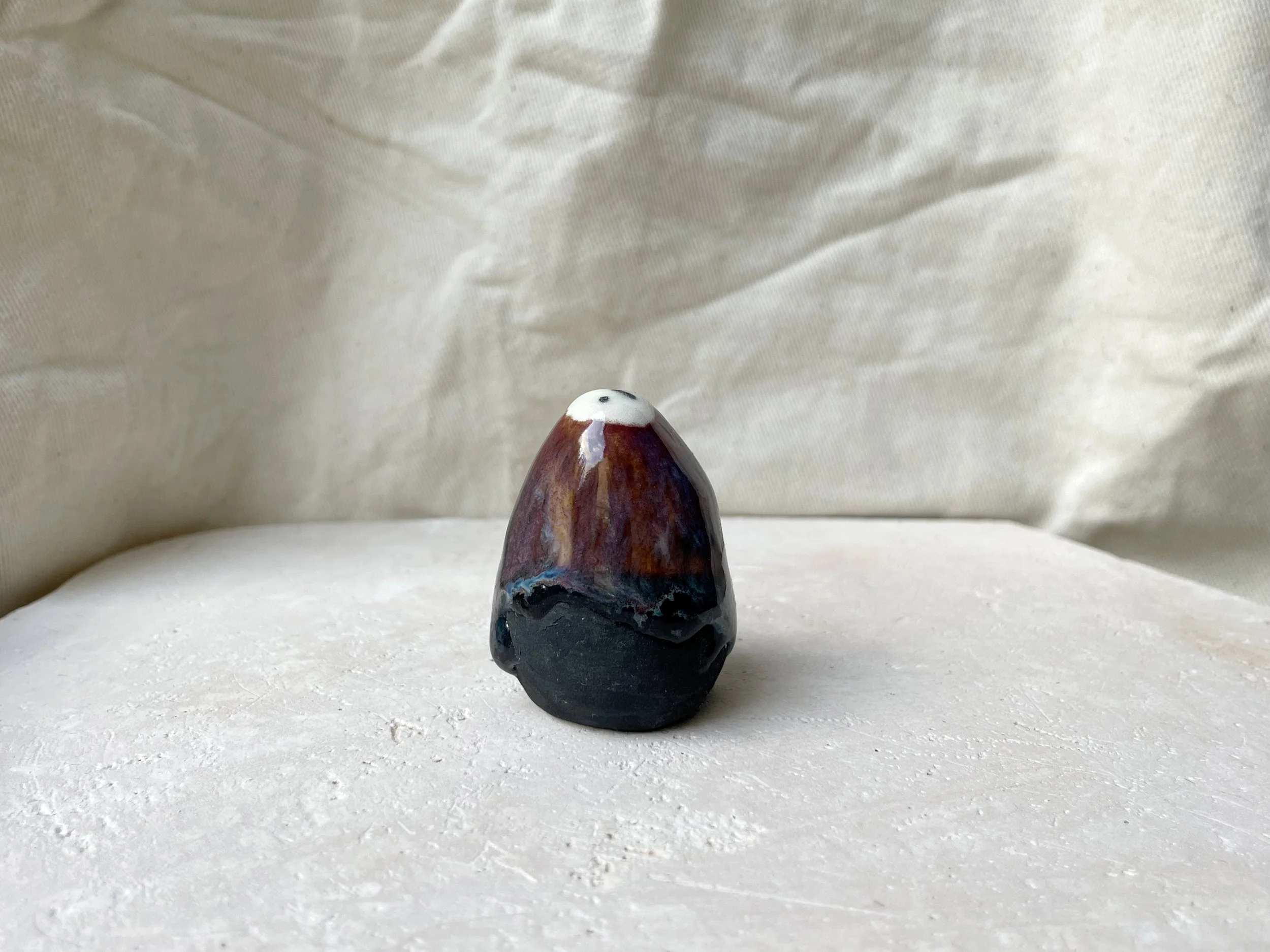 Blue, orange, purple and black handmade figurative ceramic sculpture with underglaze and drippy float glaze