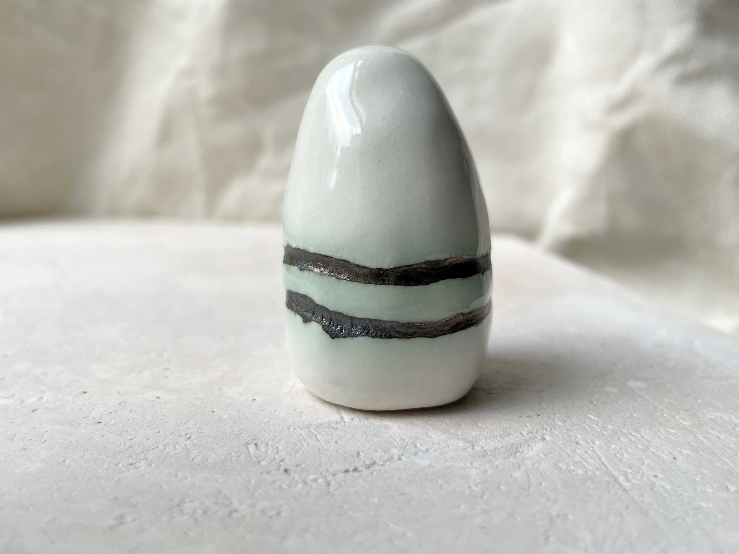 White and gold glossy handmade figurative ceramic sculpture with metallic glaze and hint of green