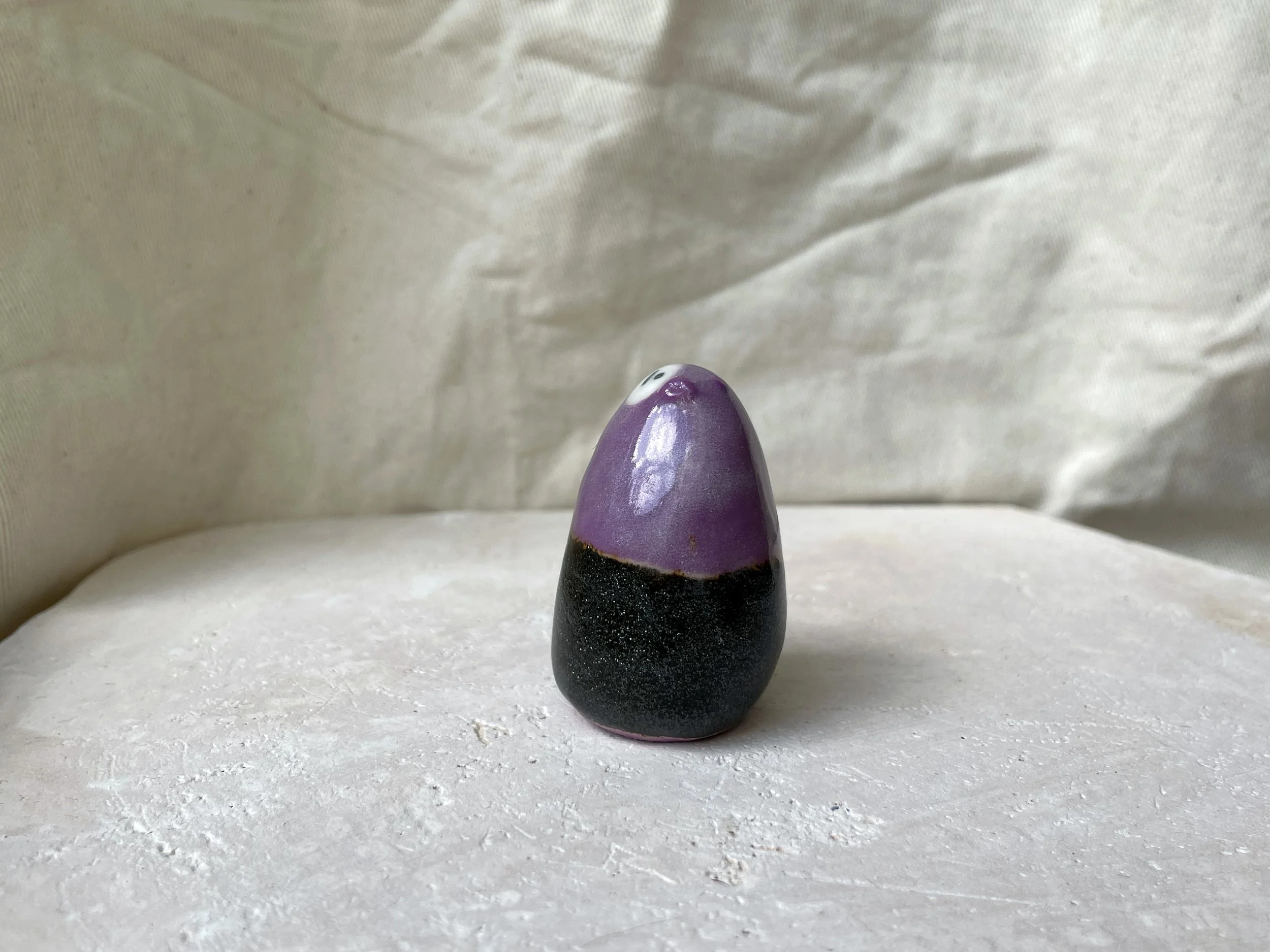 black and purple handmade figurative ceramic sculpture with sparkling cosmic glaze