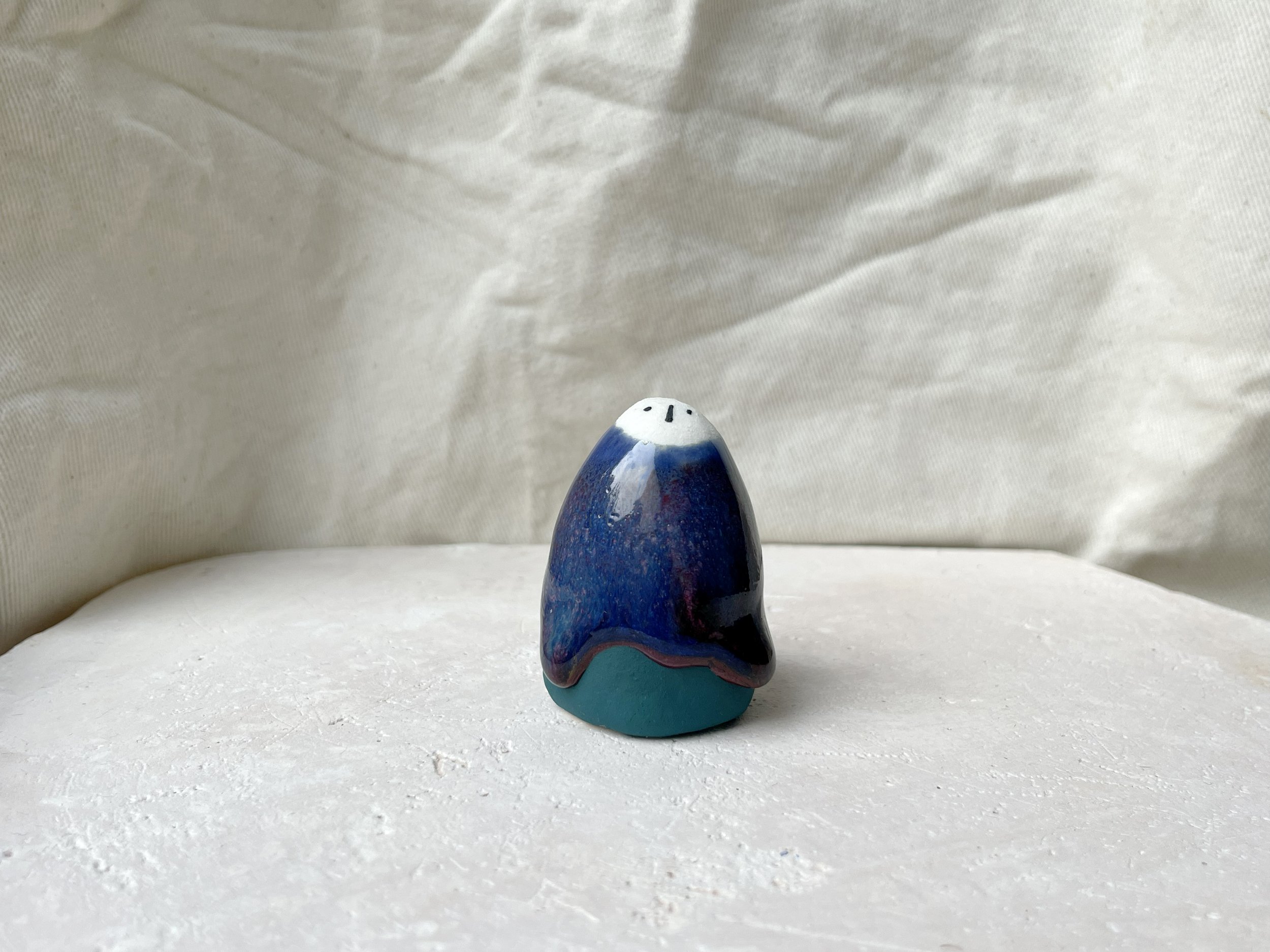 Blue, green and red handmade figurative ceramic sculpture with underglaze and drippy runny glaze