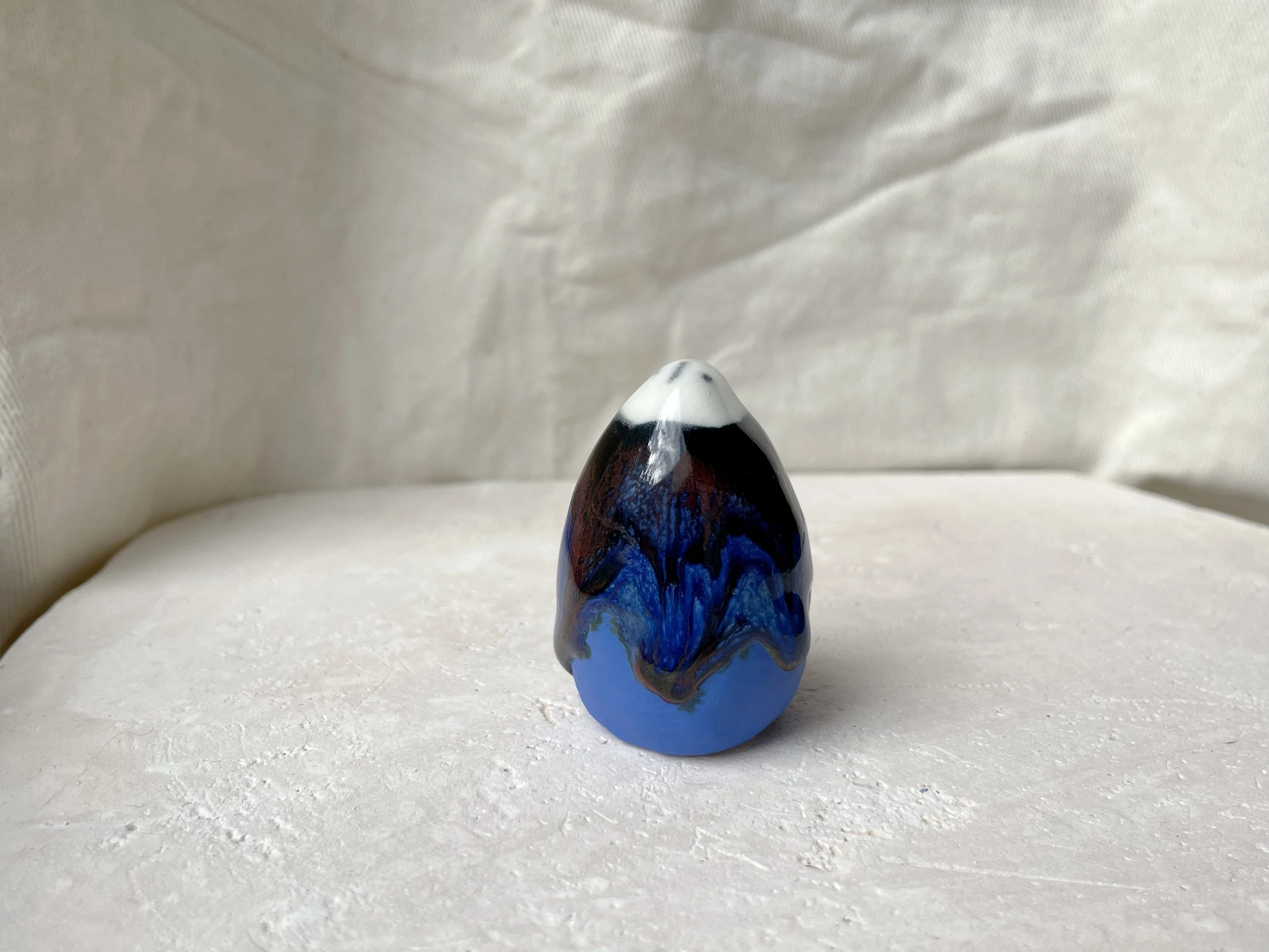 blue, red and black handmade figurative ceramic sculpture with glossy runny floating glaze