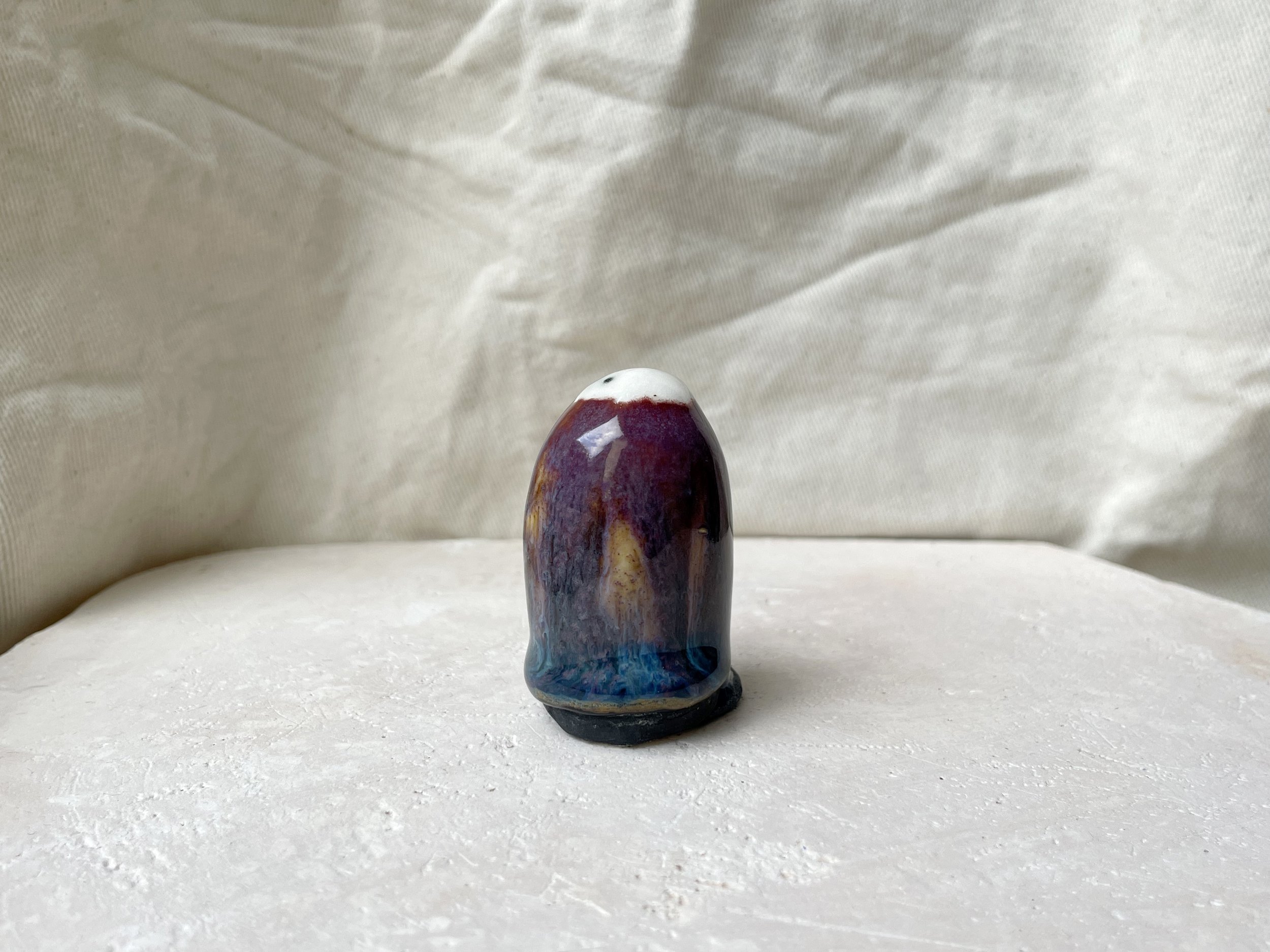 Purple, orange, blue and black handmade figurative ceramic sculpture with underglaze and drippy float glaze