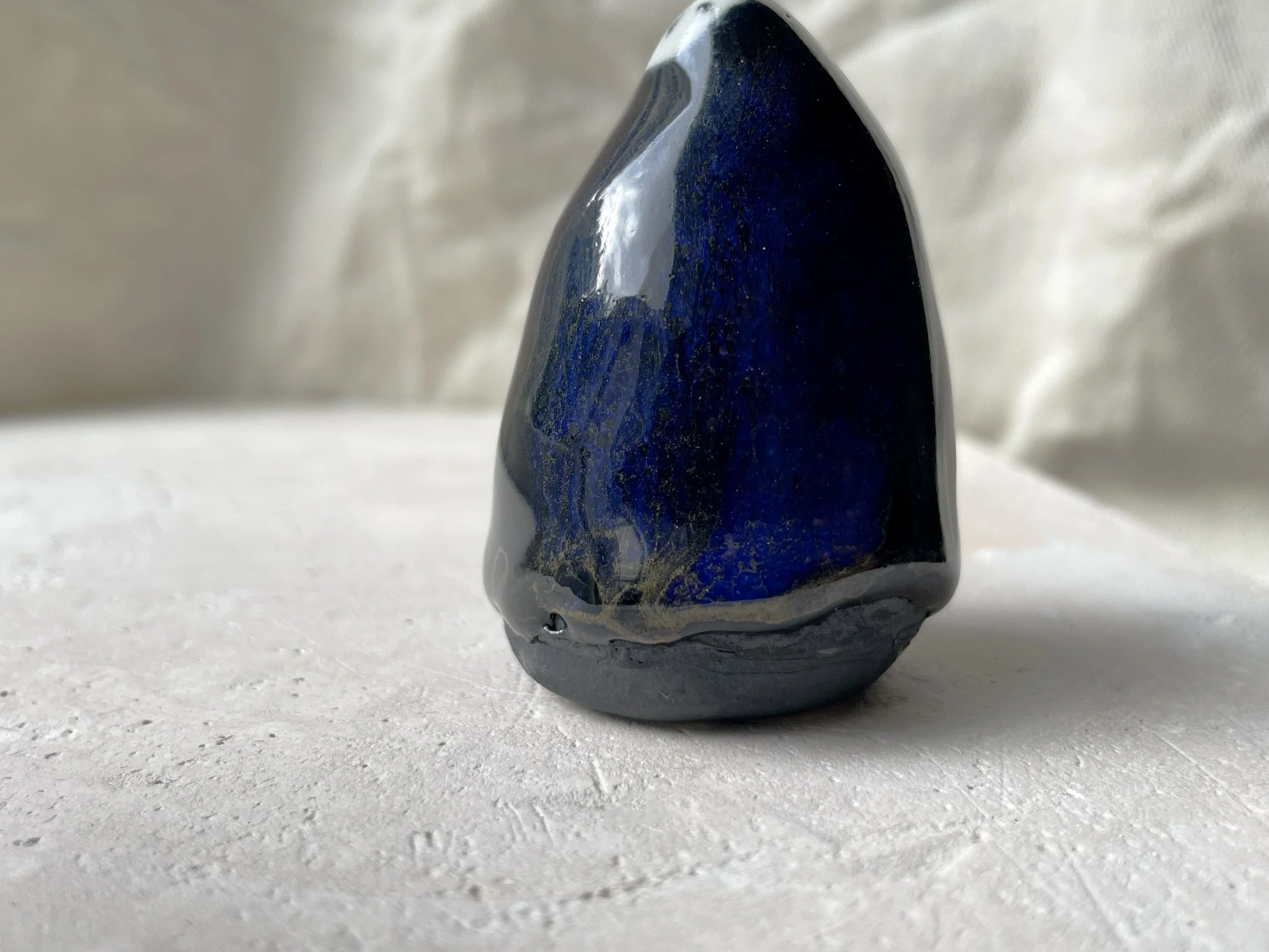 black and blue and gold handmade figurative ceramic sculpture with glossy floating glaze