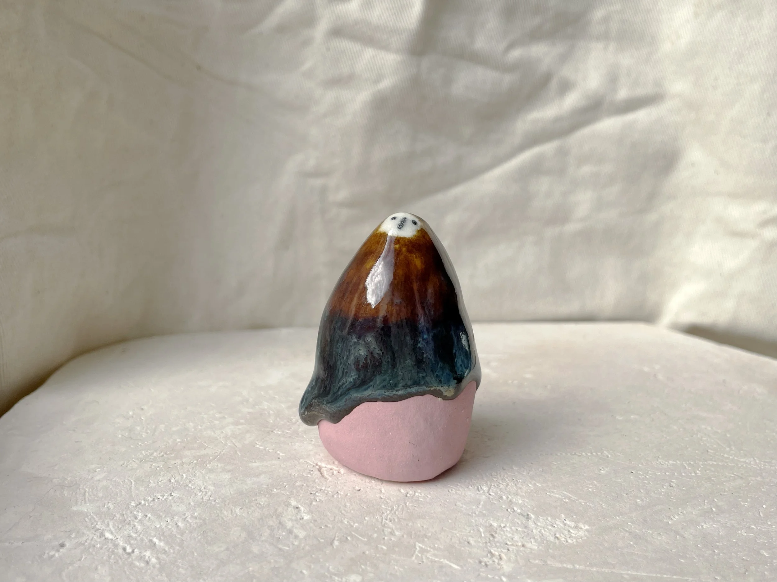 Brown, blue and pink handmade figurative ceramic sculpture with glossy drippy floating glaze