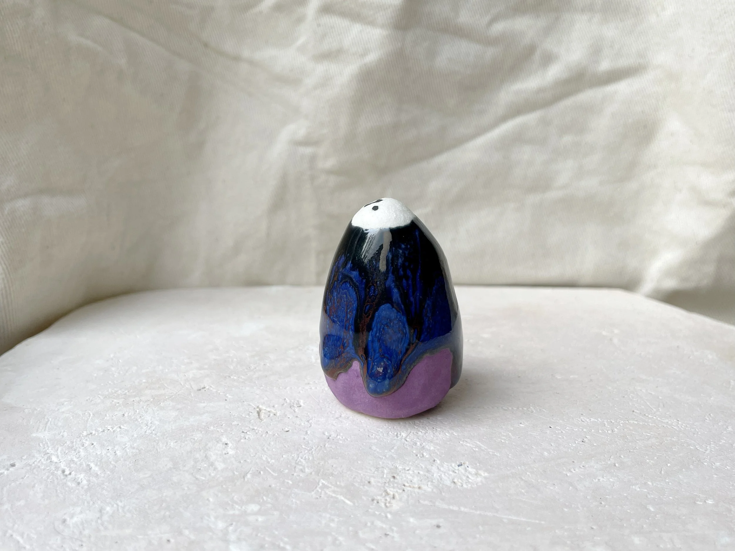 Purple, blue and black handmade figurative ceramic sculpture with glossy drippy glaze