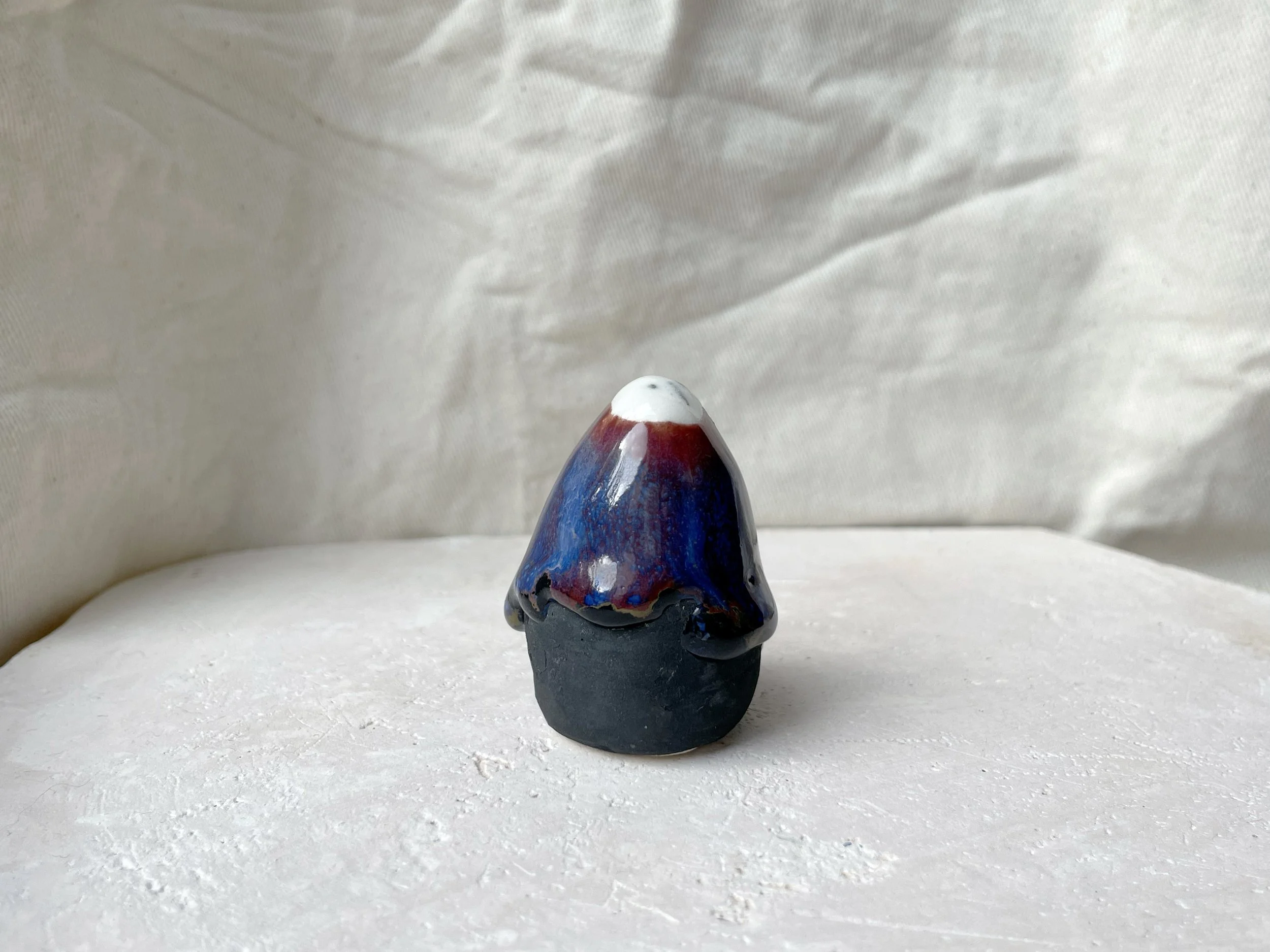 black, brown, red, blue and green handmade figurative ceramic sculpture with matte and glossy floating glaze