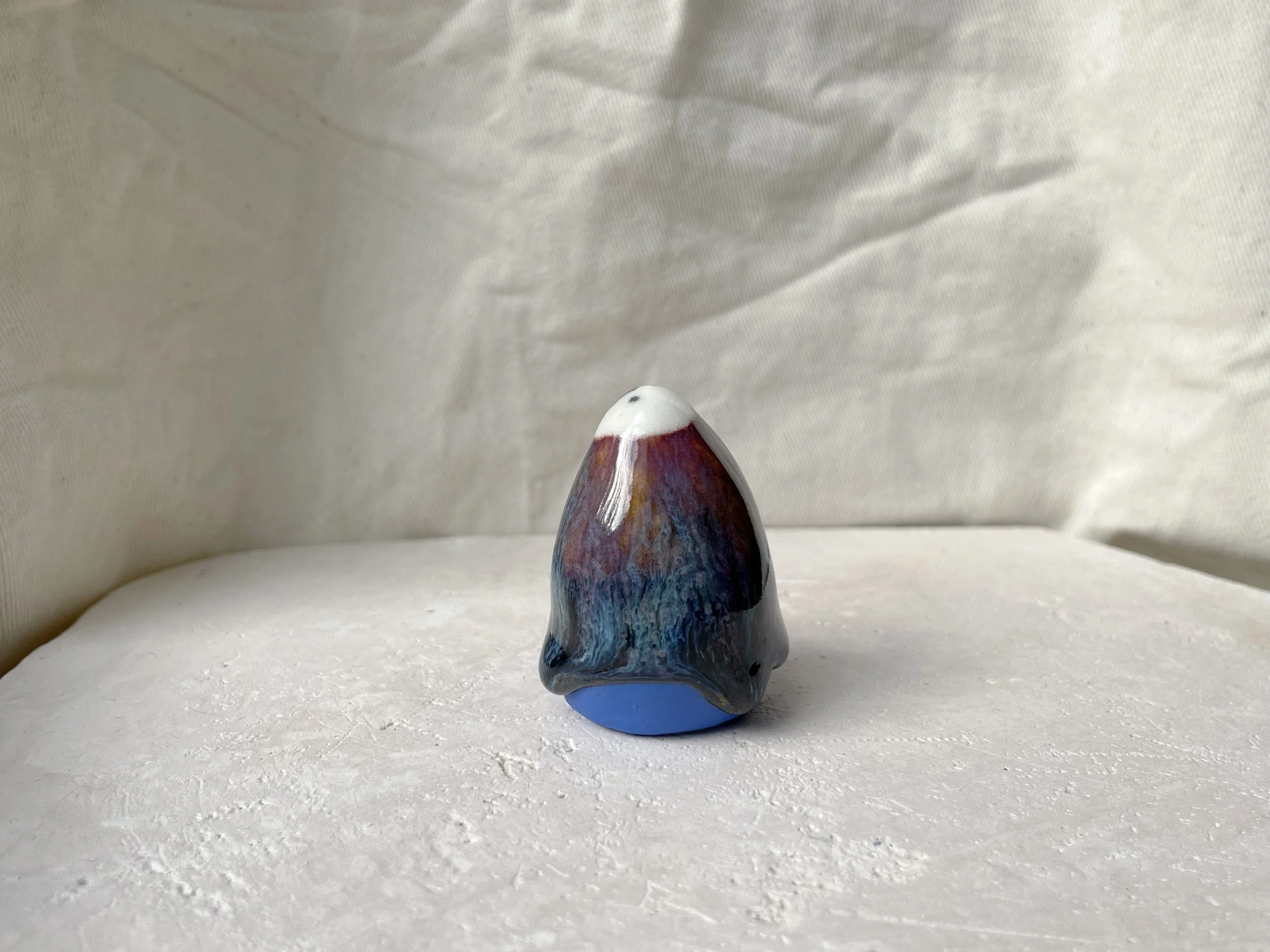 orange, purple, blue and black handmade figurative ceramic sculpture with glossy drippy floating glaze
