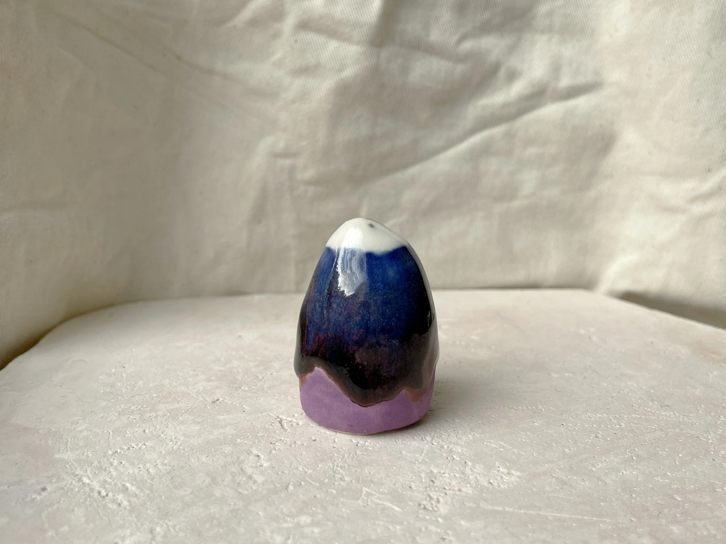 Purple, blue and red handmade figurative ceramic sculpture with glossy drippy floating glaze