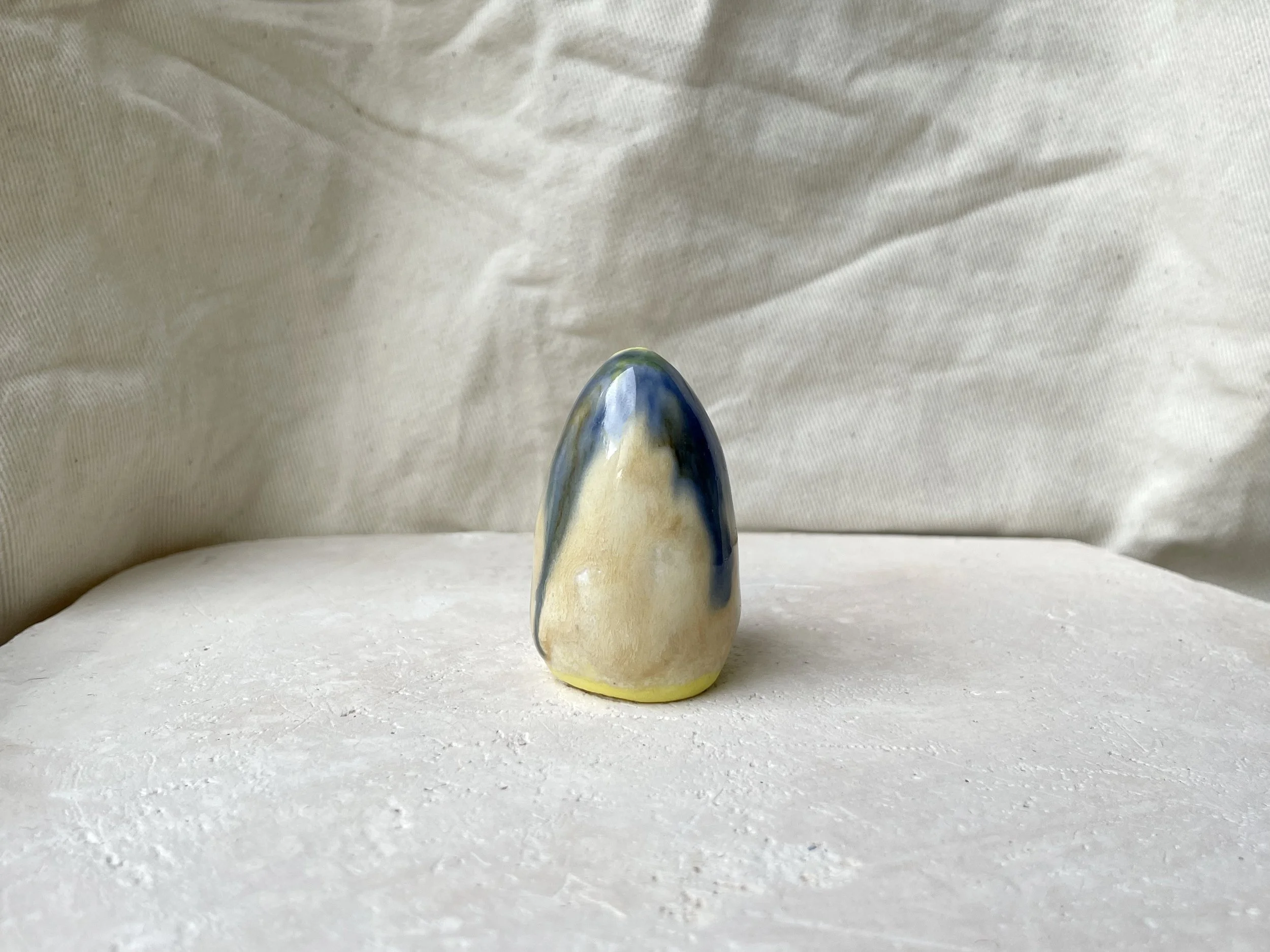 Yellow, blue and cream handmade figurative ceramic sculpture with glossy drippy glaze