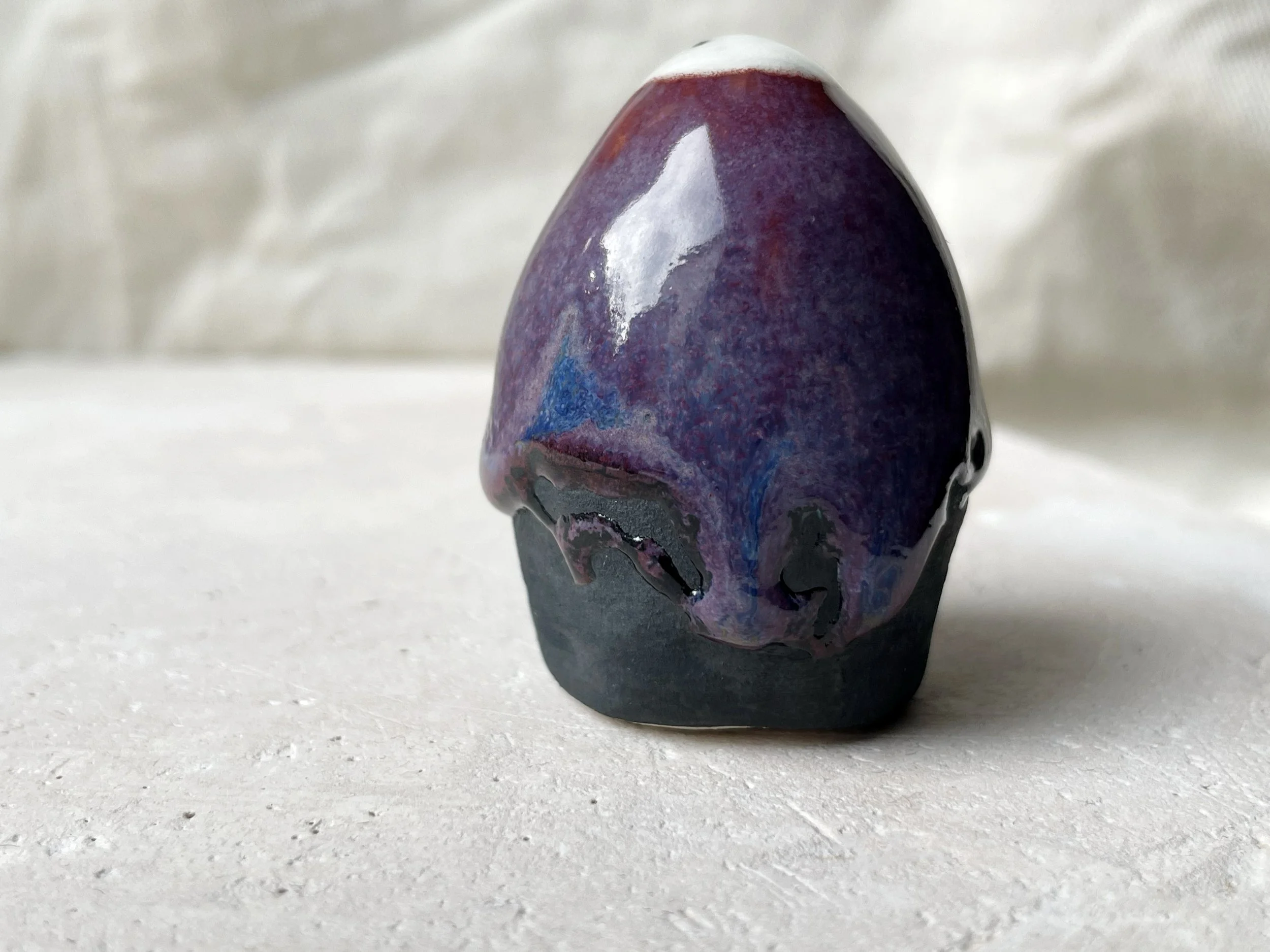 purple, black, blue handmade figurative ceramic sculpture with glossy floating glaze