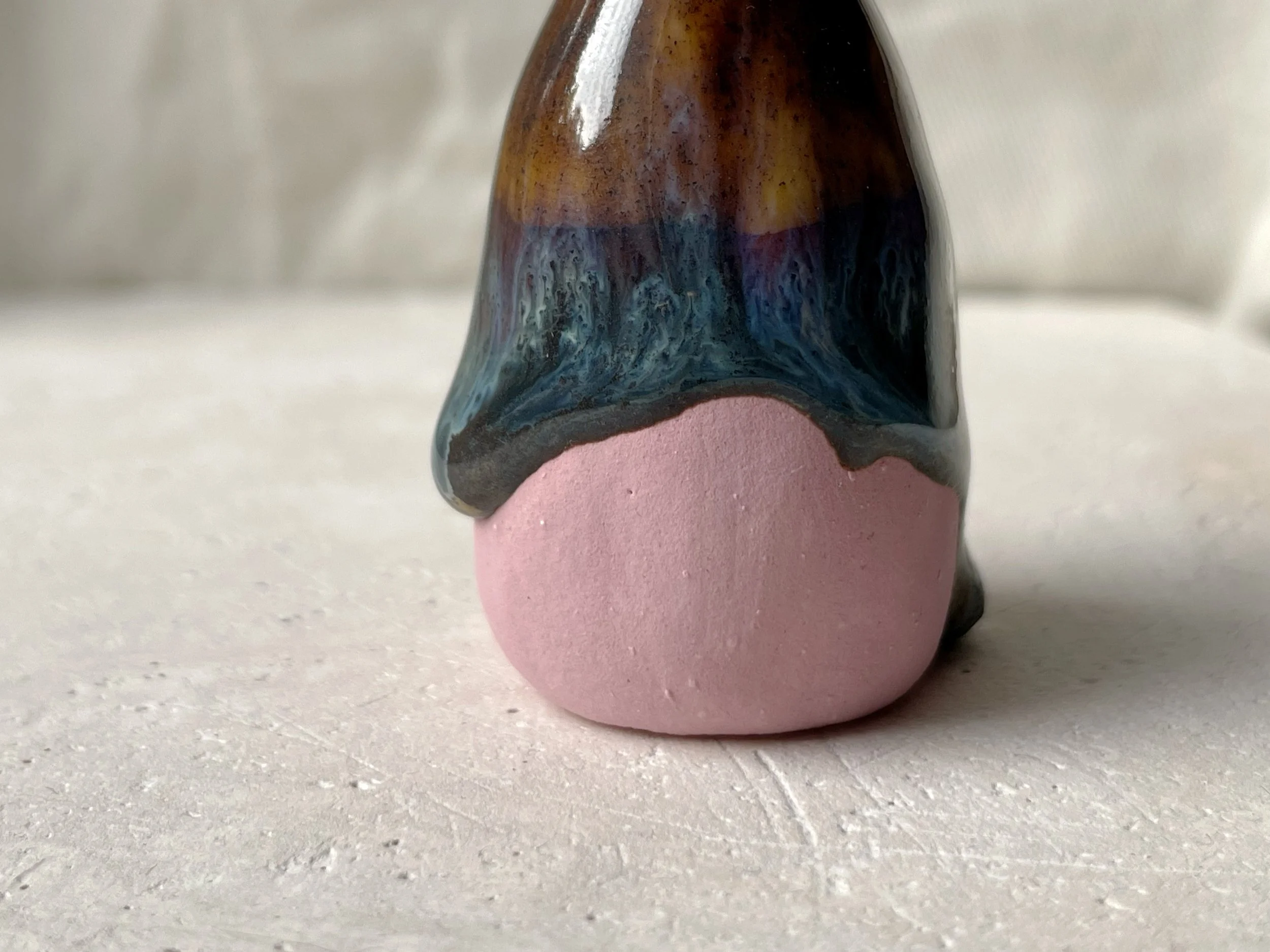 Brown, blue and pink handmade figurative ceramic sculpture with glossy drippy floating glaze