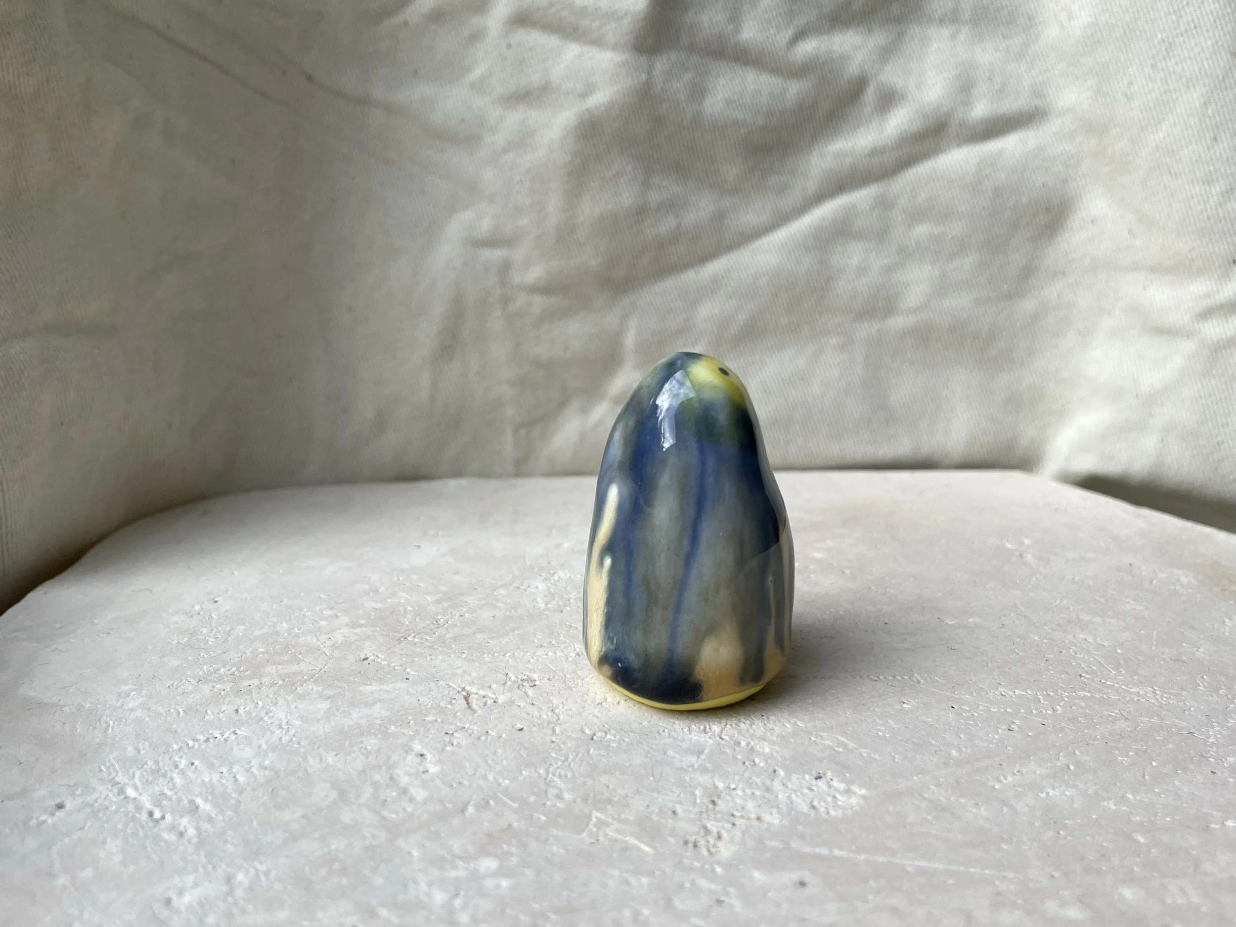 Yellow, blue and cream handmade figurative ceramic sculpture with glossy drippy glaze