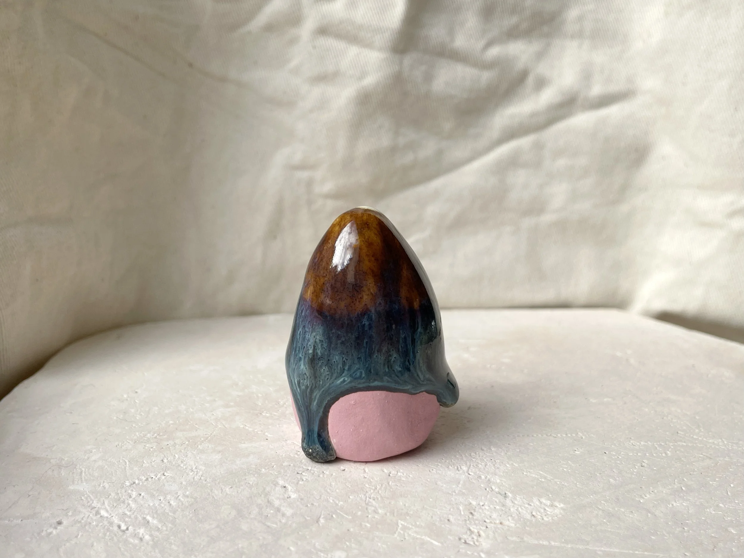Brown, blue and pink handmade figurative ceramic sculpture with glossy drippy floating glaze